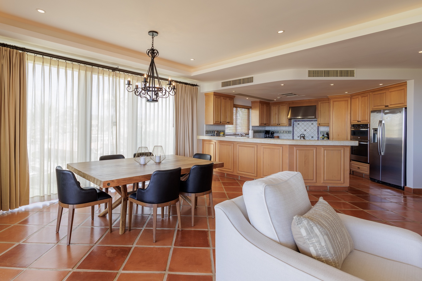 Unwind in this beautiful open living space where the dining area flows into a fully-equipped gourmet kitchen, perfect for preparing and enjoying memorable meals together.
