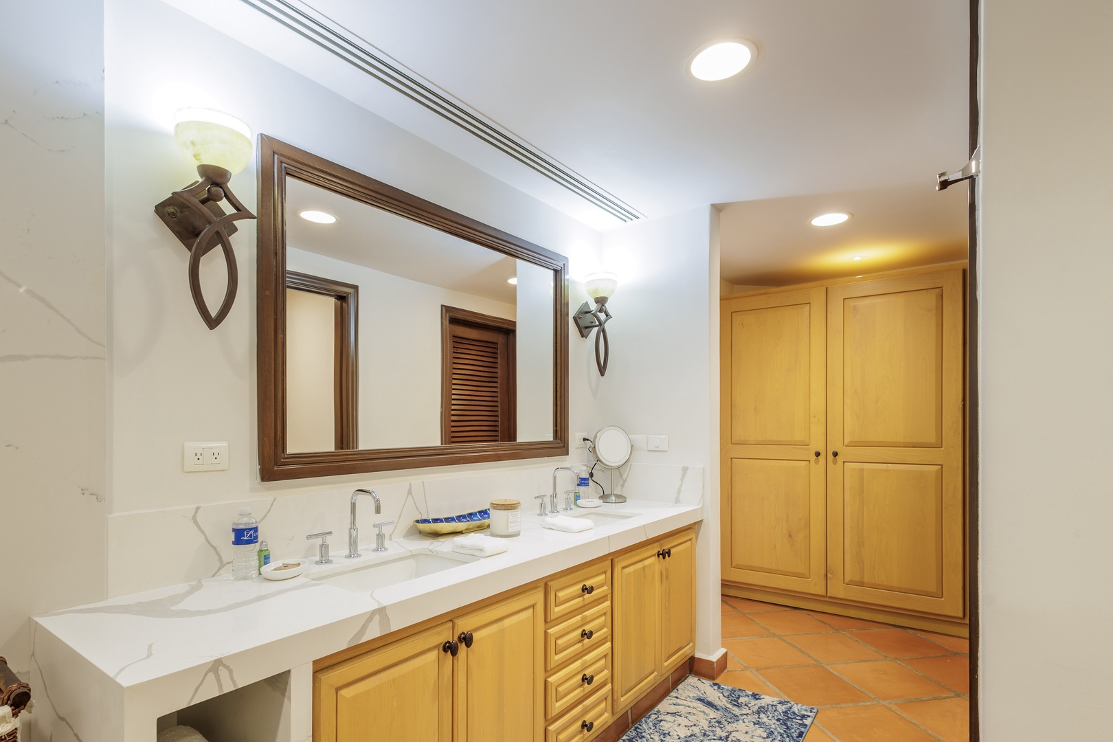 Your spacious en-suite bathroom features dual sinks with elegant cabinetry, bright lighting, and thoughtful touches that make your morning routine feel effortless and refreshing.