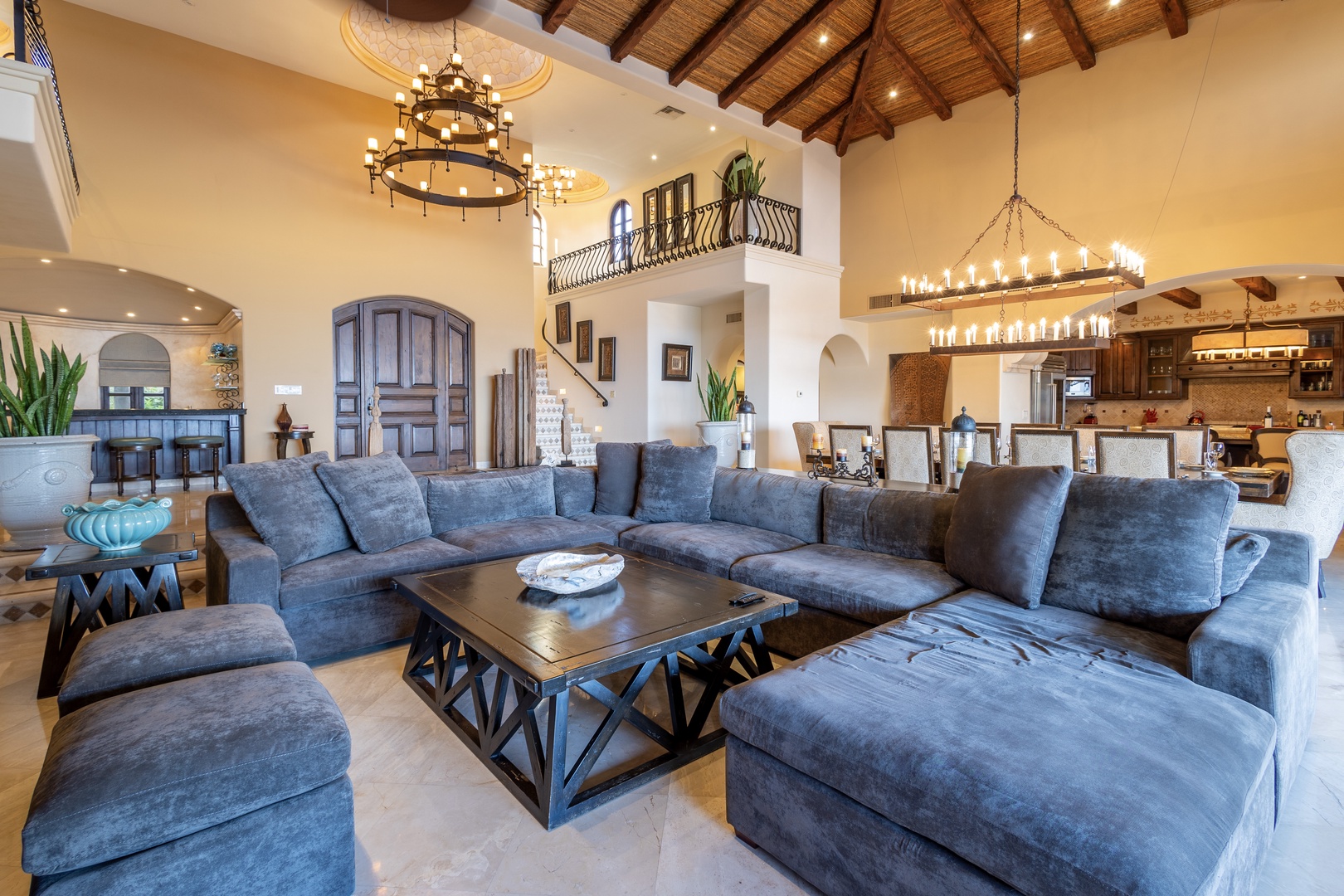 This stunning open-concept space invites you to unwind in luxury, with soaring vaulted ceilings, rustic wood beams, and elegant chandeliers that set a warm, welcoming ambiance throughout your stay.