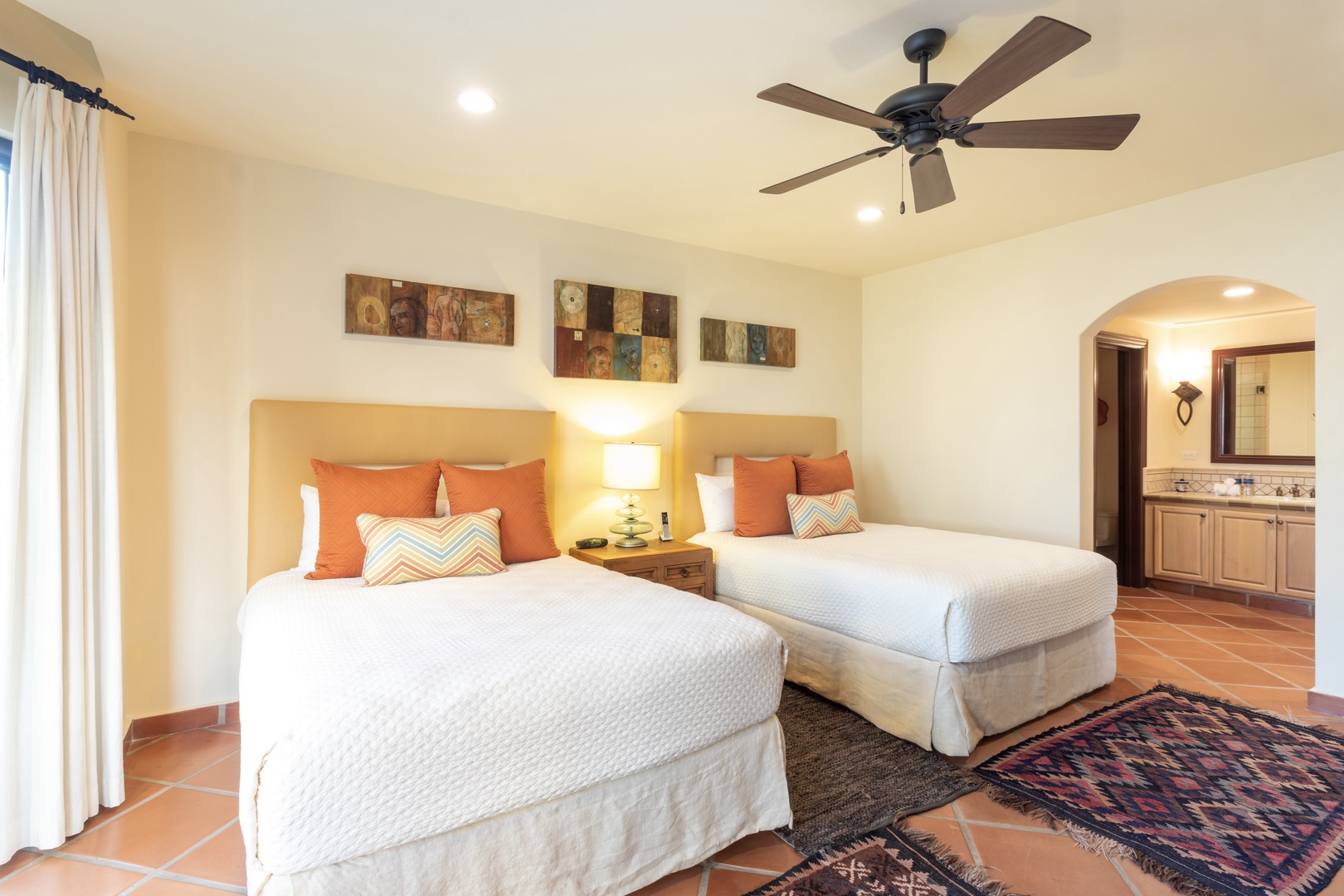 Drift off in your choice of two plush beds beneath a gentle ceiling fan, with soft linens and warm accents creating a peaceful retreat for restful nights.