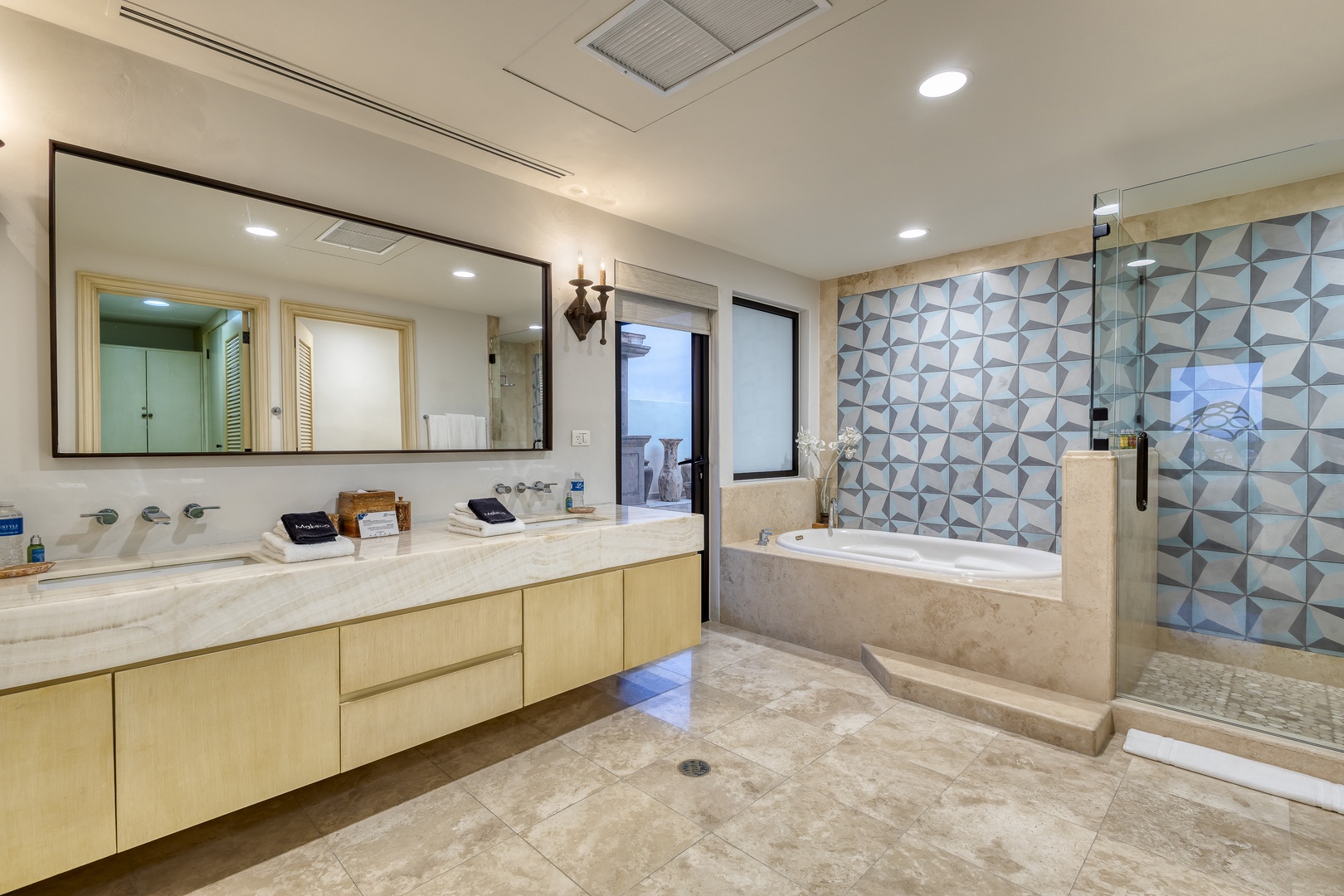 Your spacious bathroom features a soaking tub, walk-in shower, dual vanities, and modern geometric tile accents—perfect for unwinding after a day of adventure.