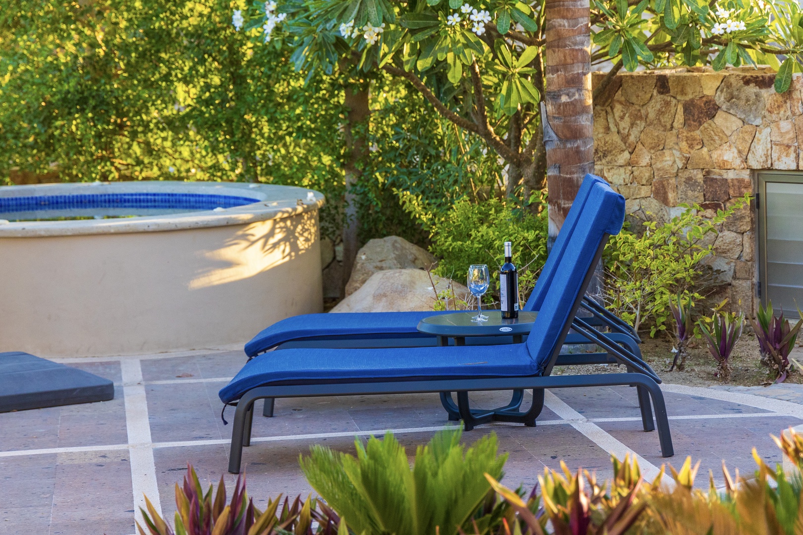 Relax poolside on your private lounge with a chilled drink, surrounded by lush tropical gardens—your perfect sunny retreat awaits.
