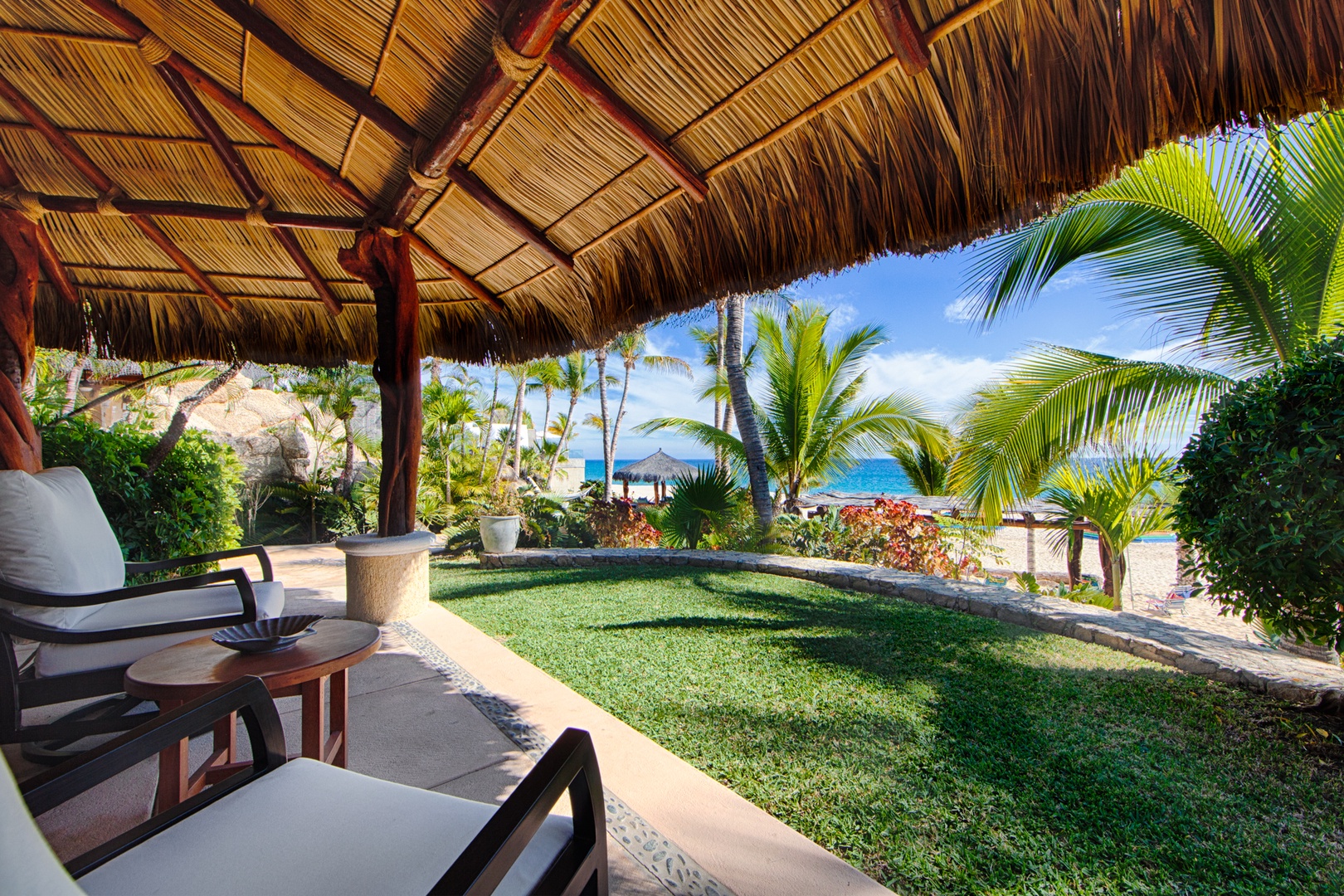 Relax under your private palapa while savoring stunning ocean views framed by swaying palms and manicured gardens.