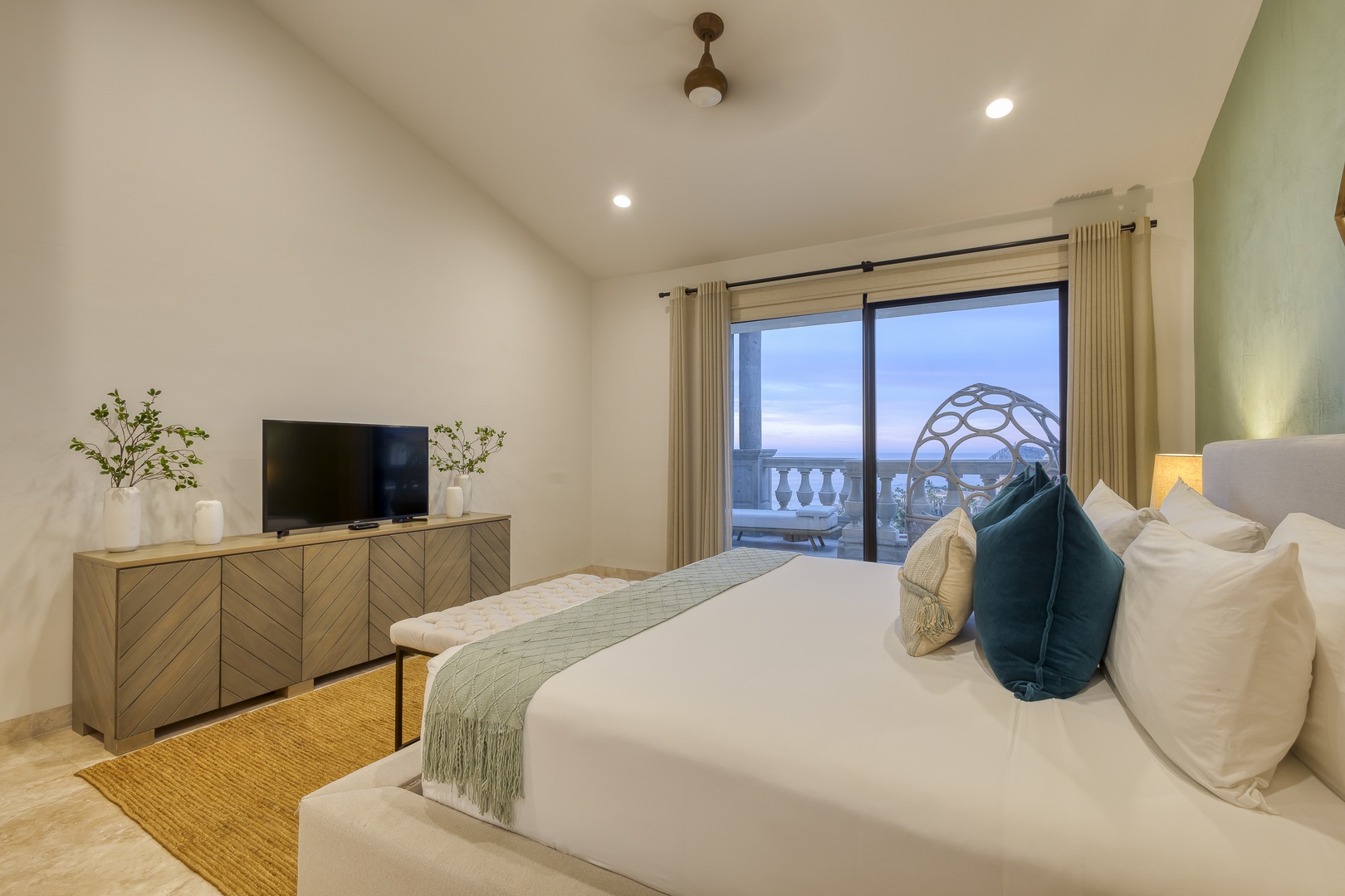 Unwind in your serene bedroom featuring crisp white linens, stylish décor, and a private balcony overlooking tranquil ocean views—your perfect escape awaits.