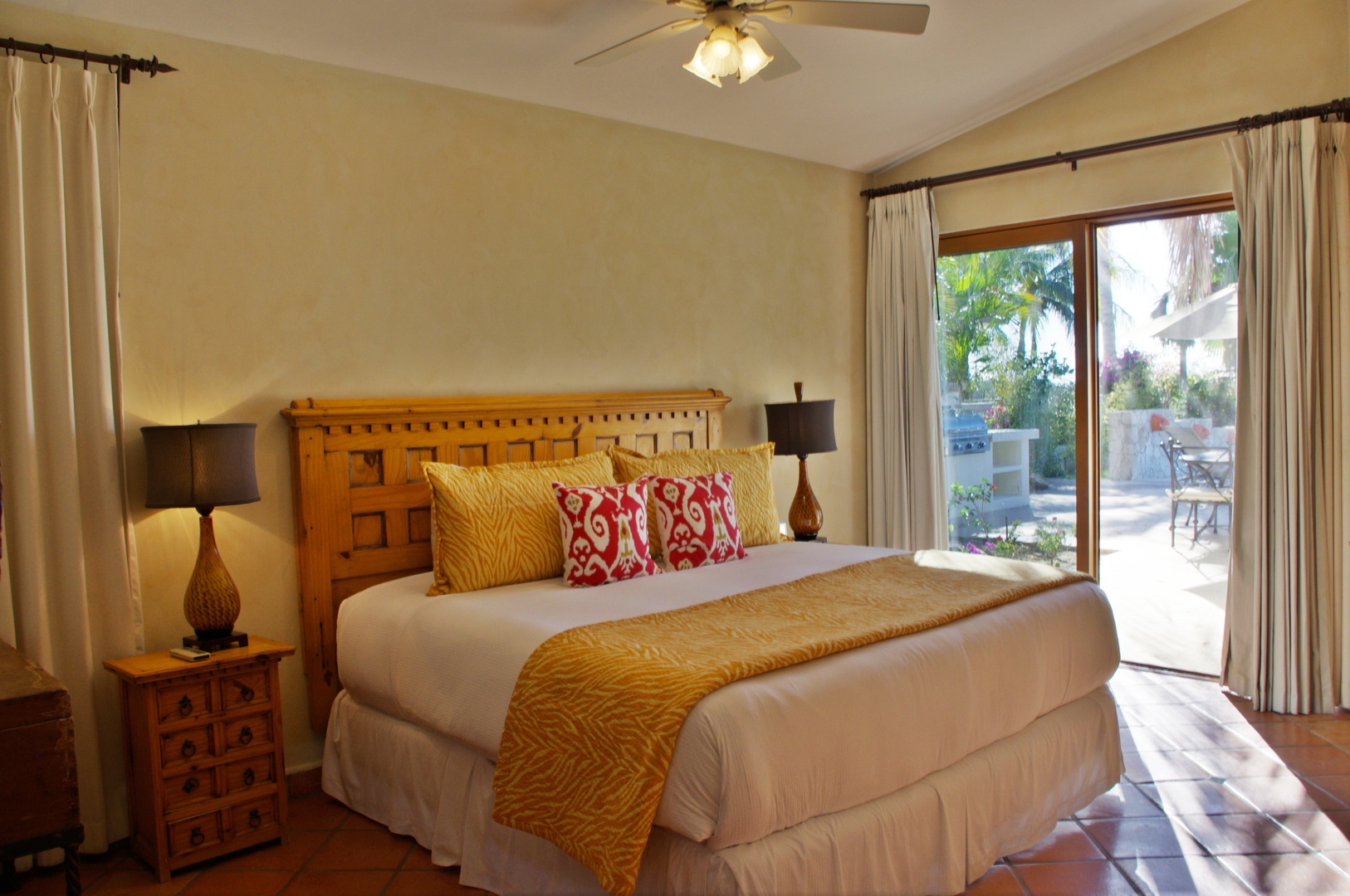 Wake up to sunlight streaming through your private patio doors, where tropical gardens invite you to step outside. Relax under the ceiling fan and unwind in this bright, inviting retreat.