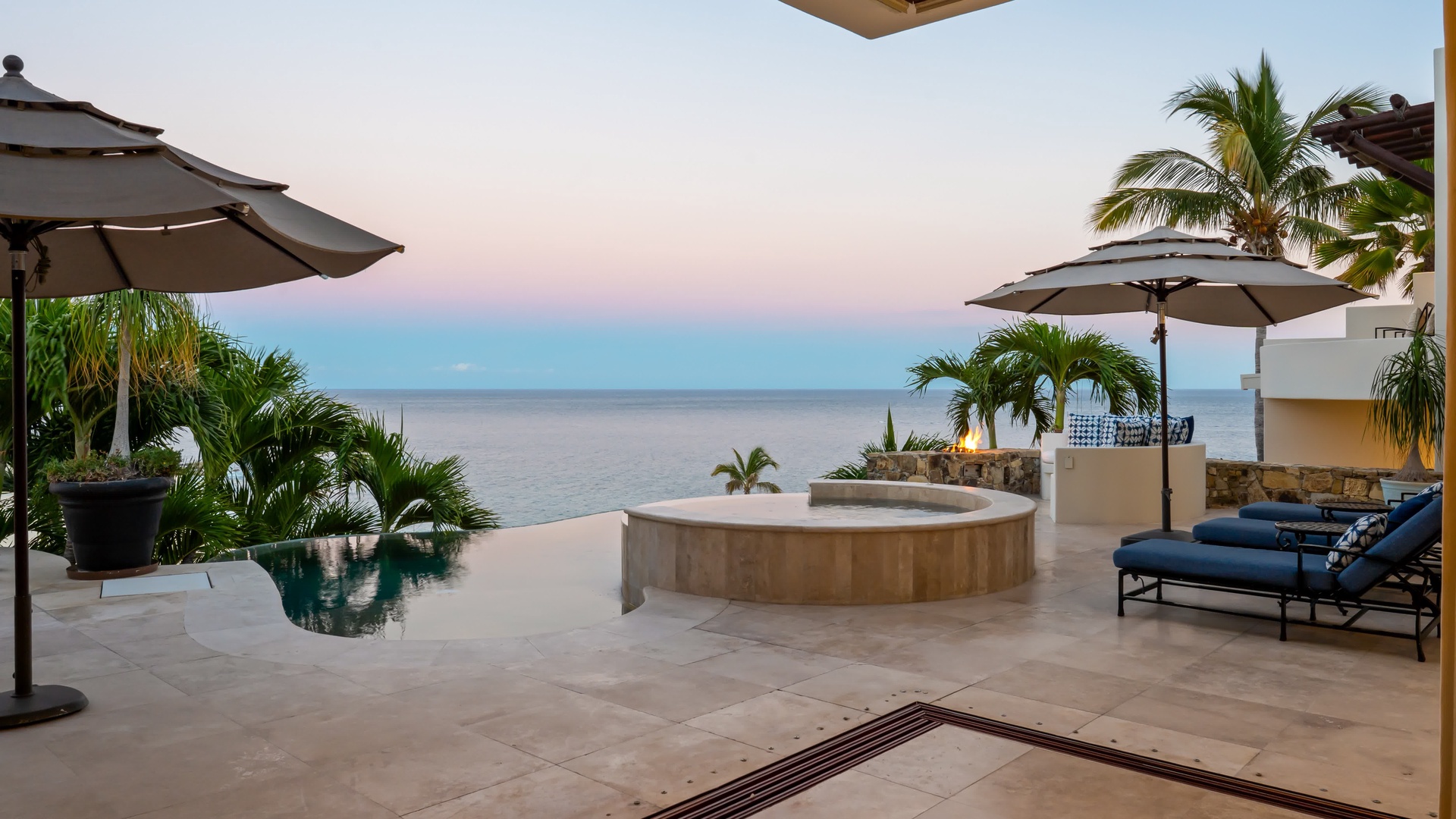 Soak in your private hot tub as sunset paints the sky, while infinity pool waters mirror the tropical paradise around you.
