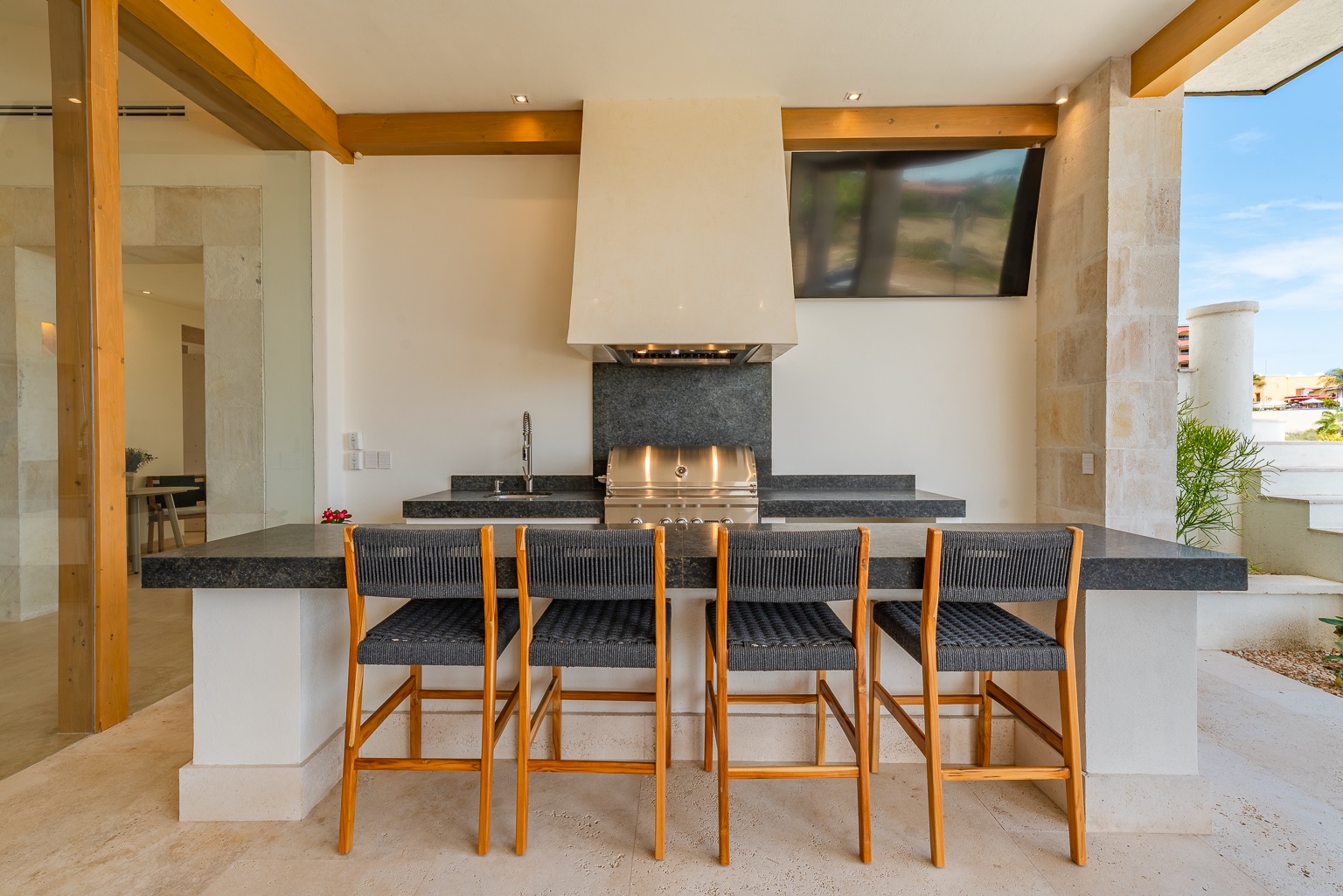 Gather around your sleek outdoor kitchen bar, perfect for sunset grilling and coastal breezes. The built-in grill and counter seating invite effortless entertaining under open skies.