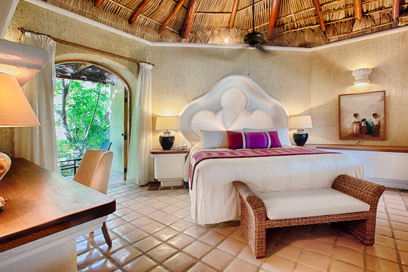 Your dreamy bedroom awaits beneath a stunning palapa roof with arched doorway framing lush tropical greenery.