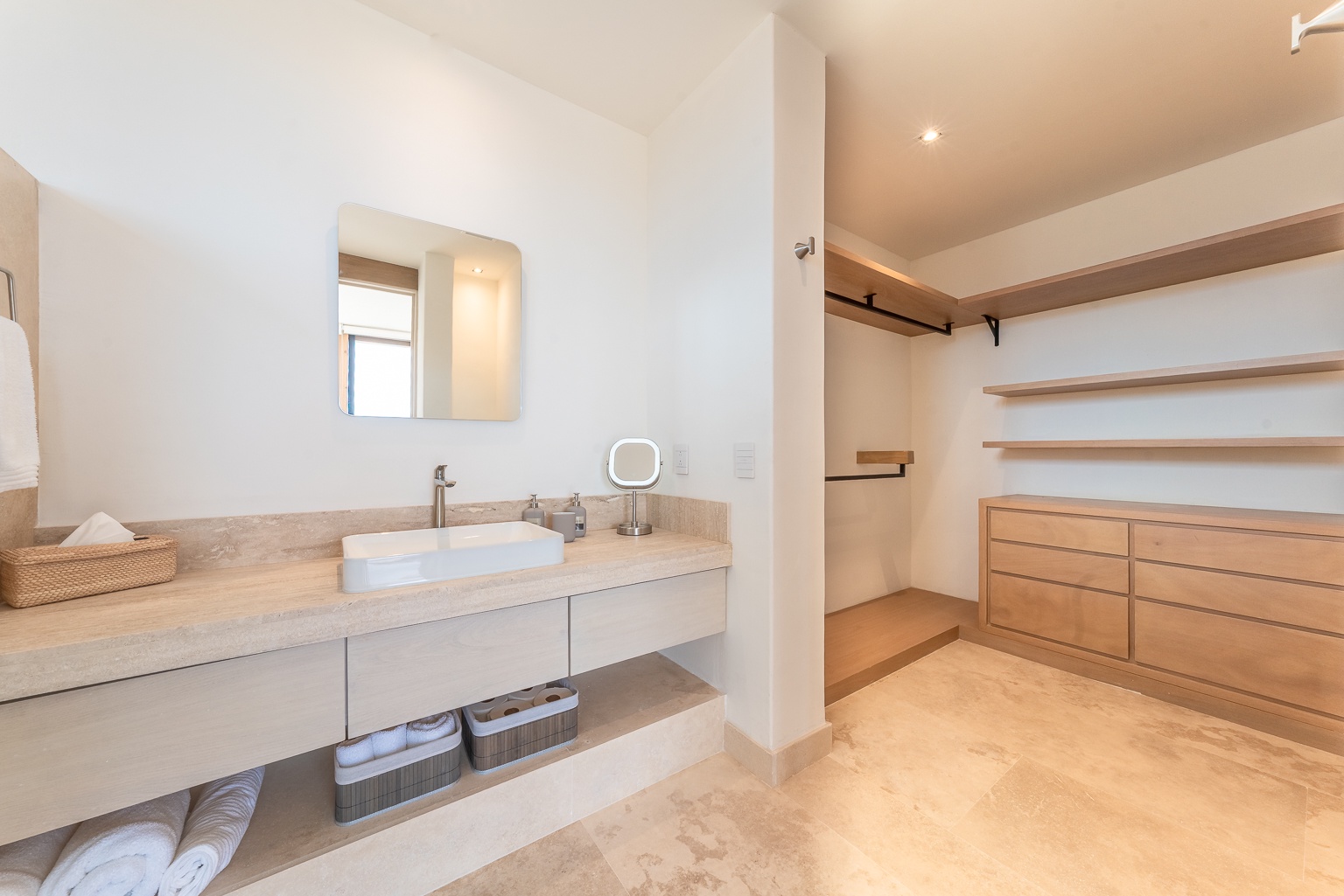 Your ensuite features sleek stone countertops, a modern vessel sink, and a spacious walk-in closet with custom wood shelving—everything you need to unpack and feel at home.
