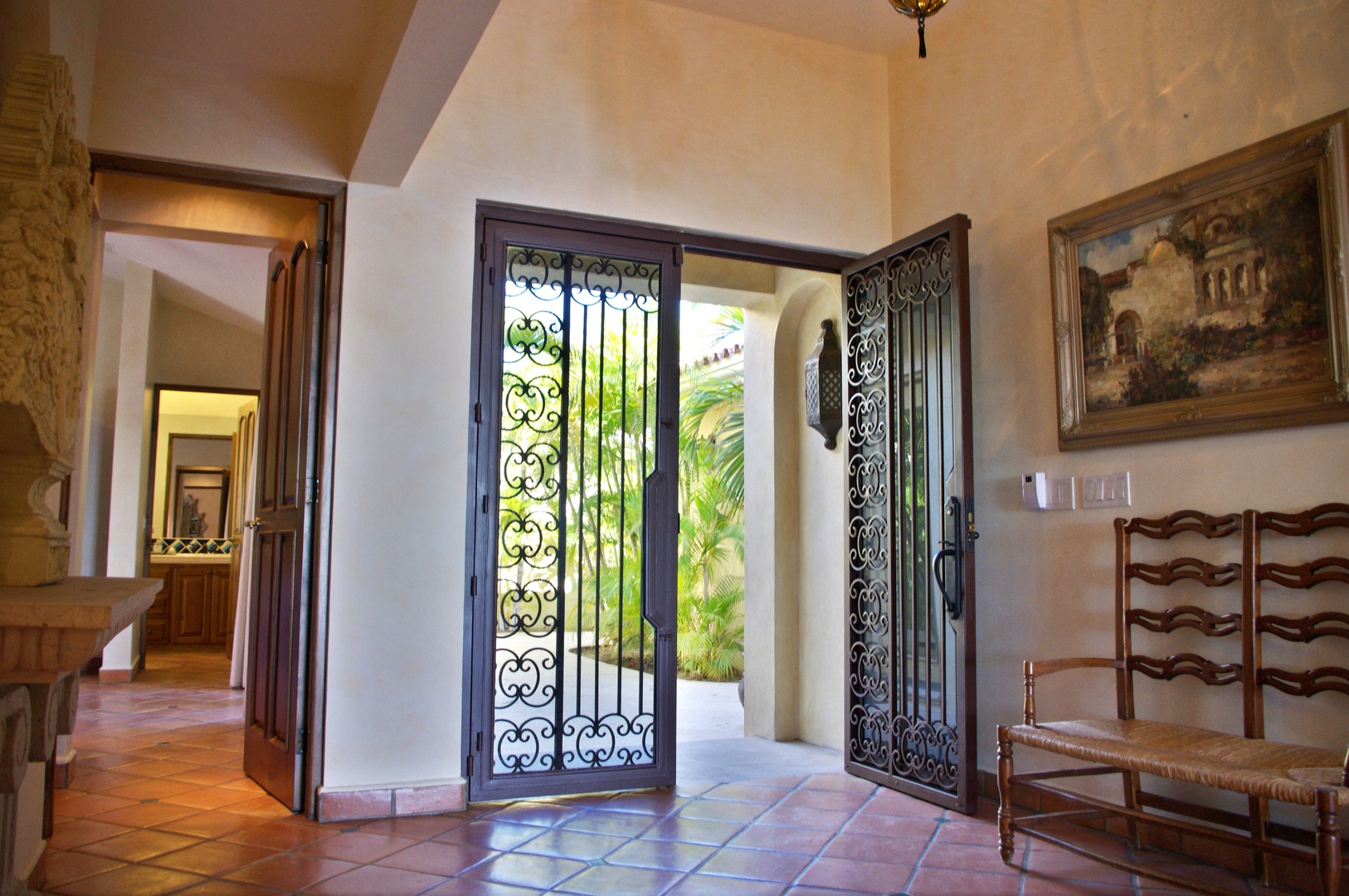 The entryway opens to lush greenery, inviting you into a space where old-world charm and tranquil courtyards blend seamlessly—just step inside.