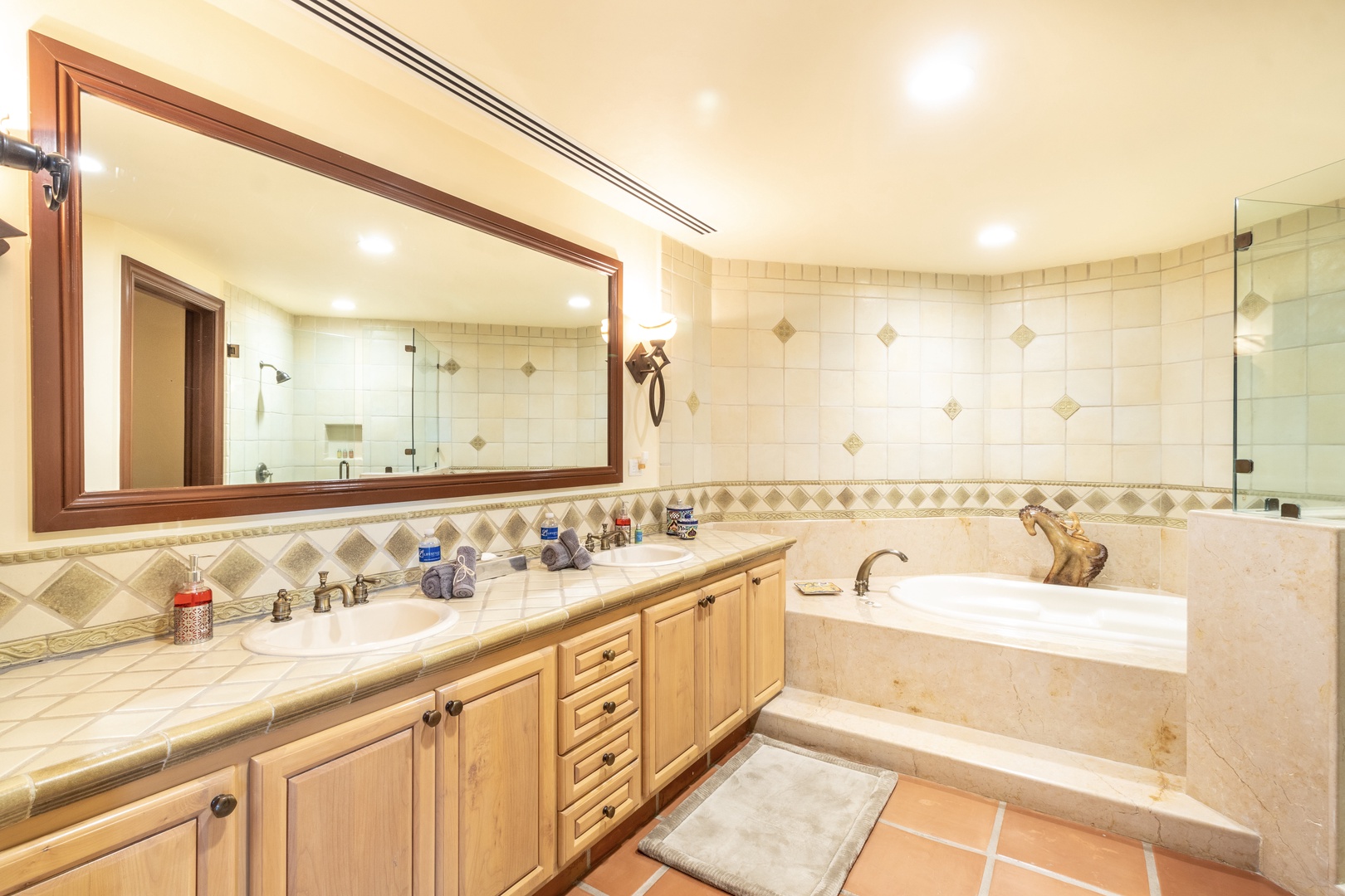 Your spacious bathroom features elegant marble surfaces, double vanities, and a soaking tub—perfect for unwinding after a day of adventures in paradise.
