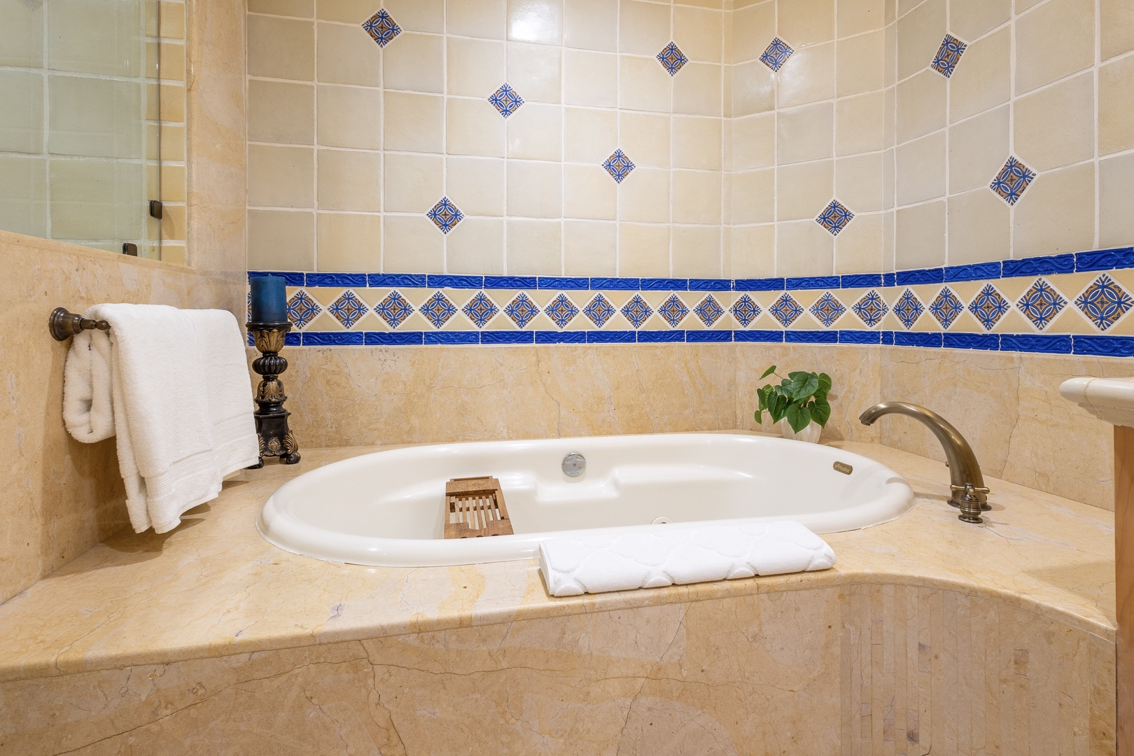Sink into your private soaking tub surrounded by beautiful Mediterranean-style tiles and thoughtful touches like fluffy towels and a natural wood caddy.