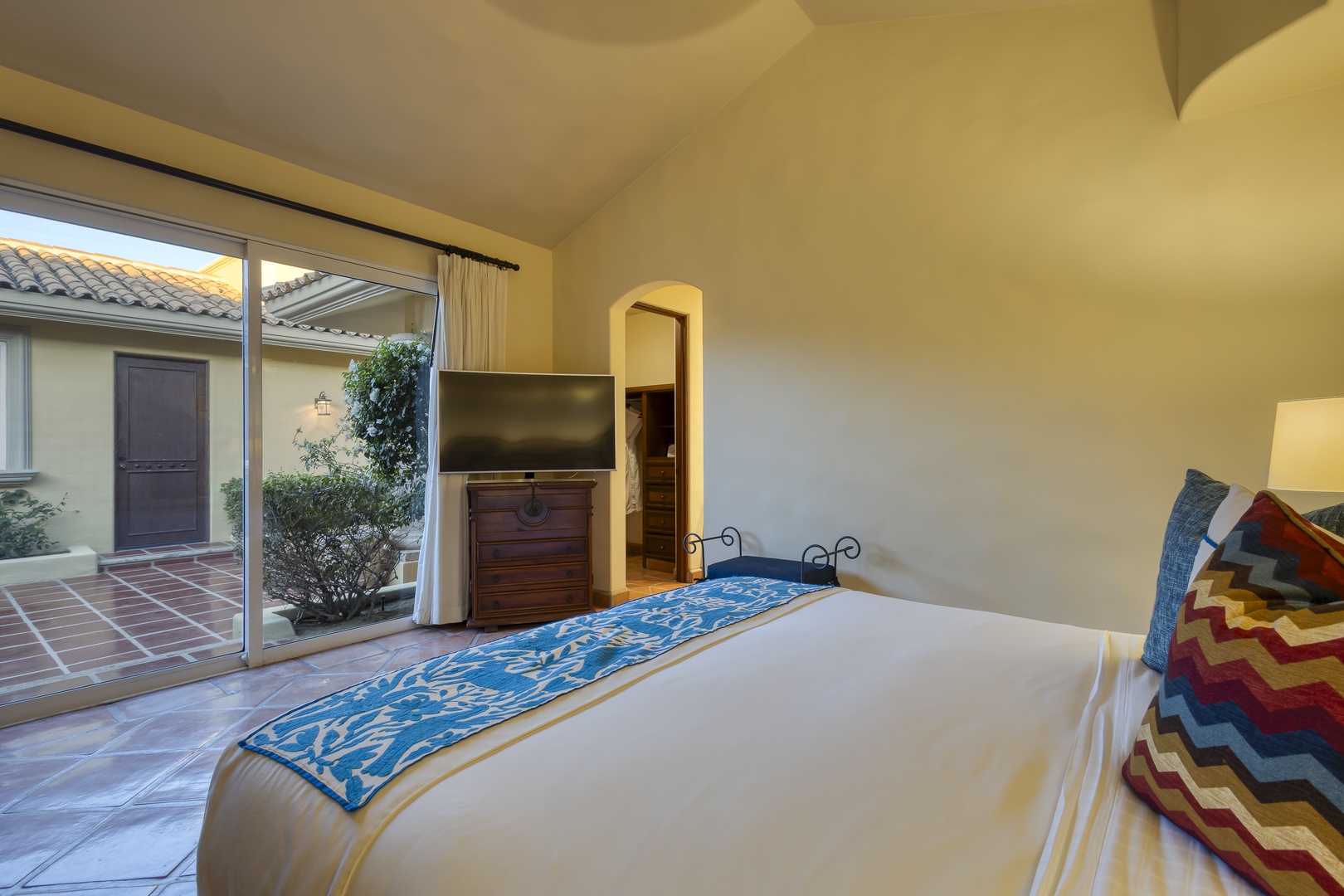 Drift into peaceful sleep on crisp white linens, with colorful pillows adding charm to your private sanctuary.