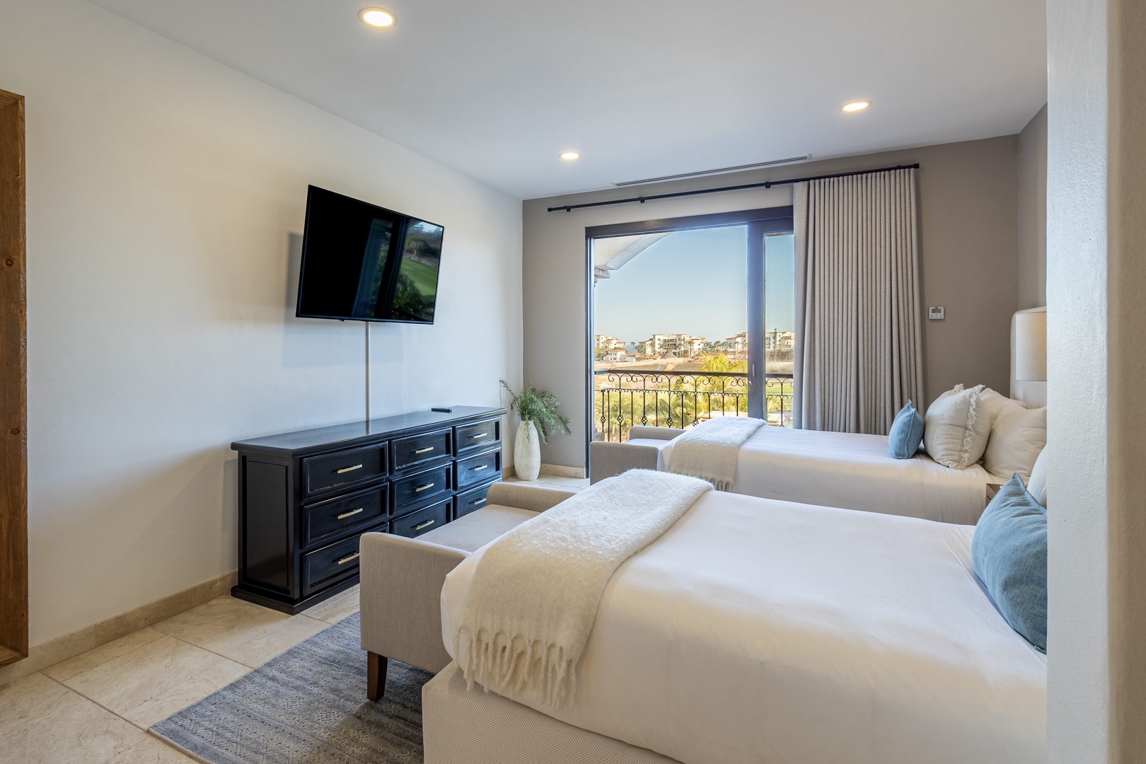 Wake up to bright city views from two inviting beds dressed in soft linens. Your private balcony awaits just beyond the sliding door, perfect for morning coffee or evening relaxation.