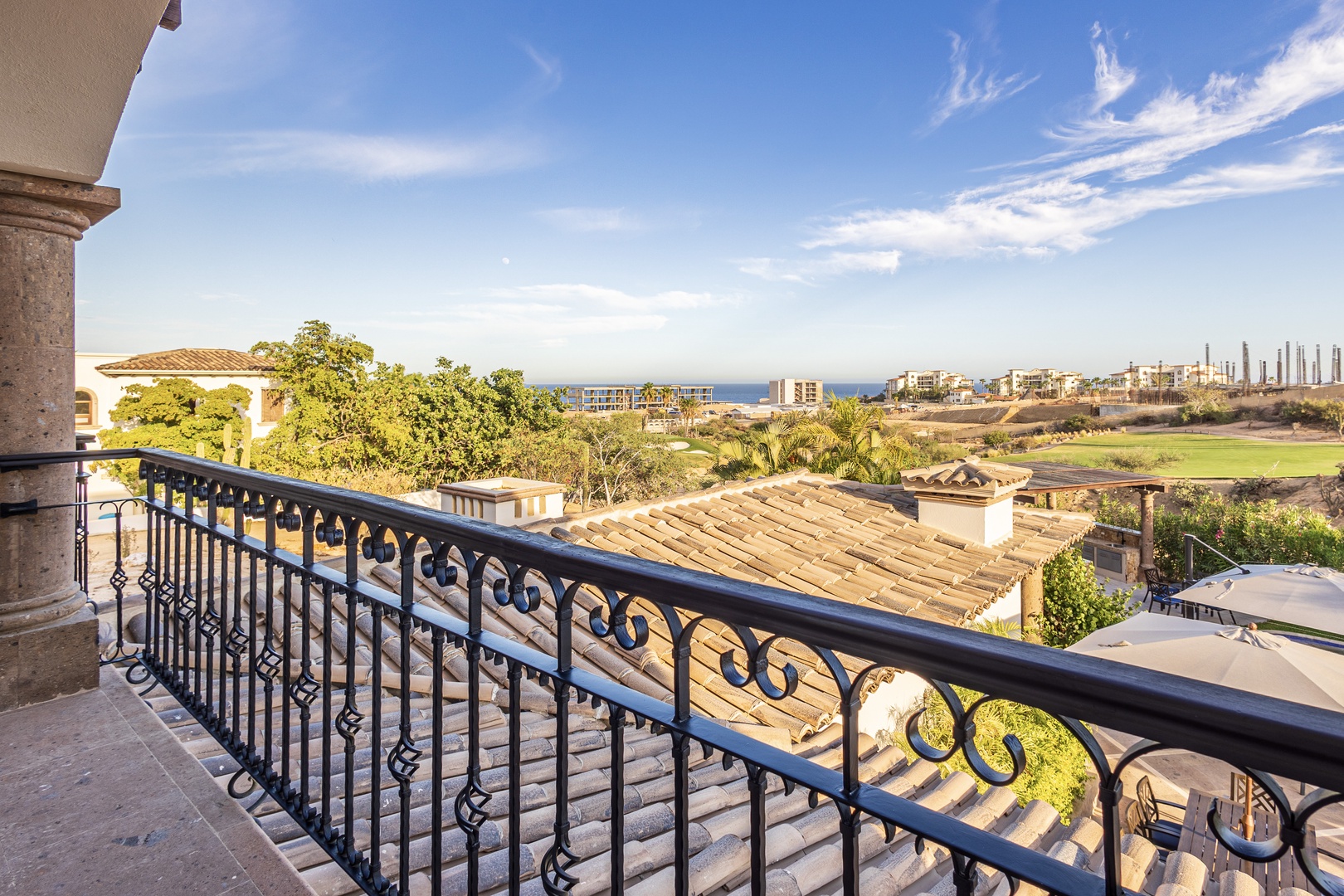 Coastal scenery and distant ocean views define the surroundings, with lush greenery and neighboring structures forming the backdrop of this vacation rental's location.