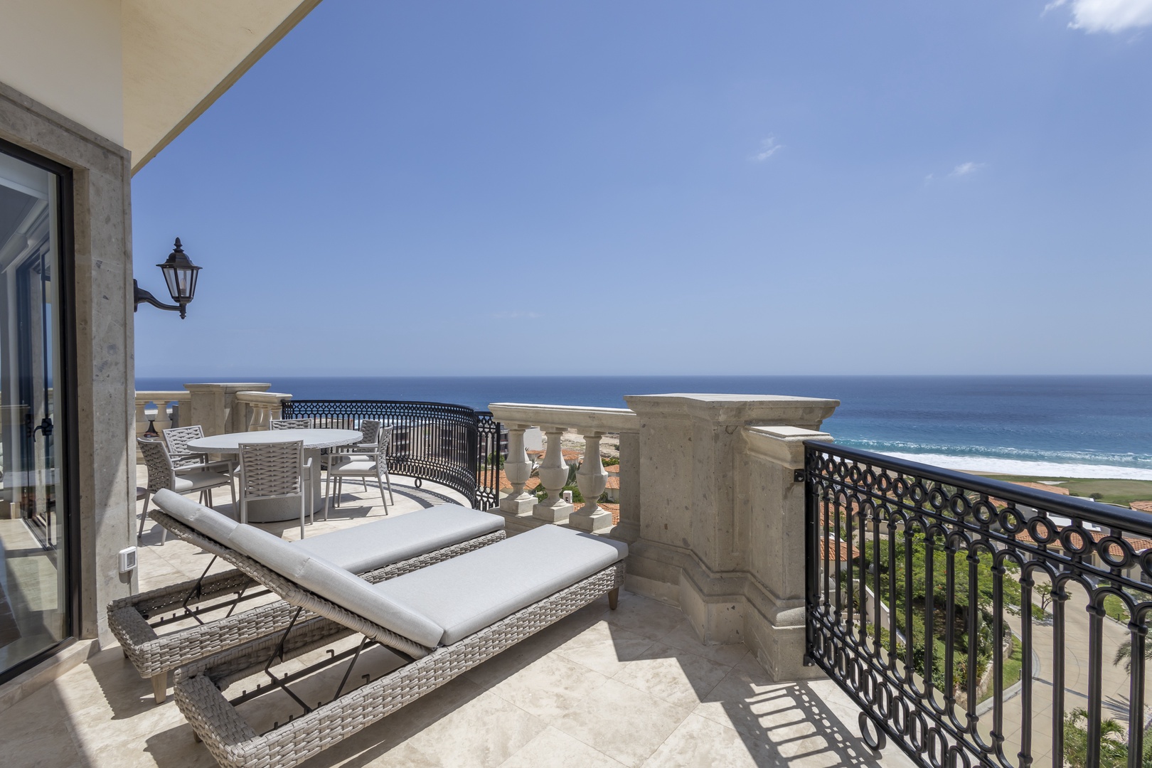 Spacious oceanfront terrace featuring comfortable lounge seating and outdoor dining with sweeping sea views, perfect for morning coffee or sunset cocktails.