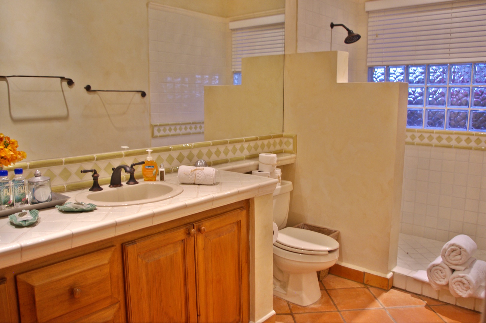 Step into your private bathroom where fresh towels await and warm natural light filters through. The walk-in shower invites you to refresh after a day exploring, while thoughtful amenities ensure comfort throughout your stay.