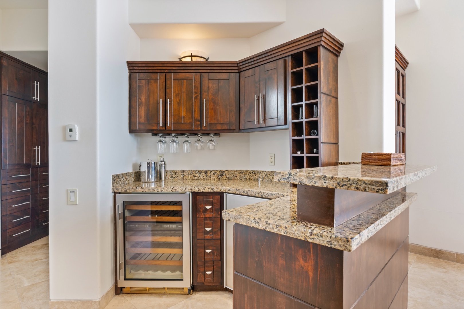 Your gourmet kitchen features rich wood cabinetry, granite counters, and a wine fridge for perfect evening gatherings.