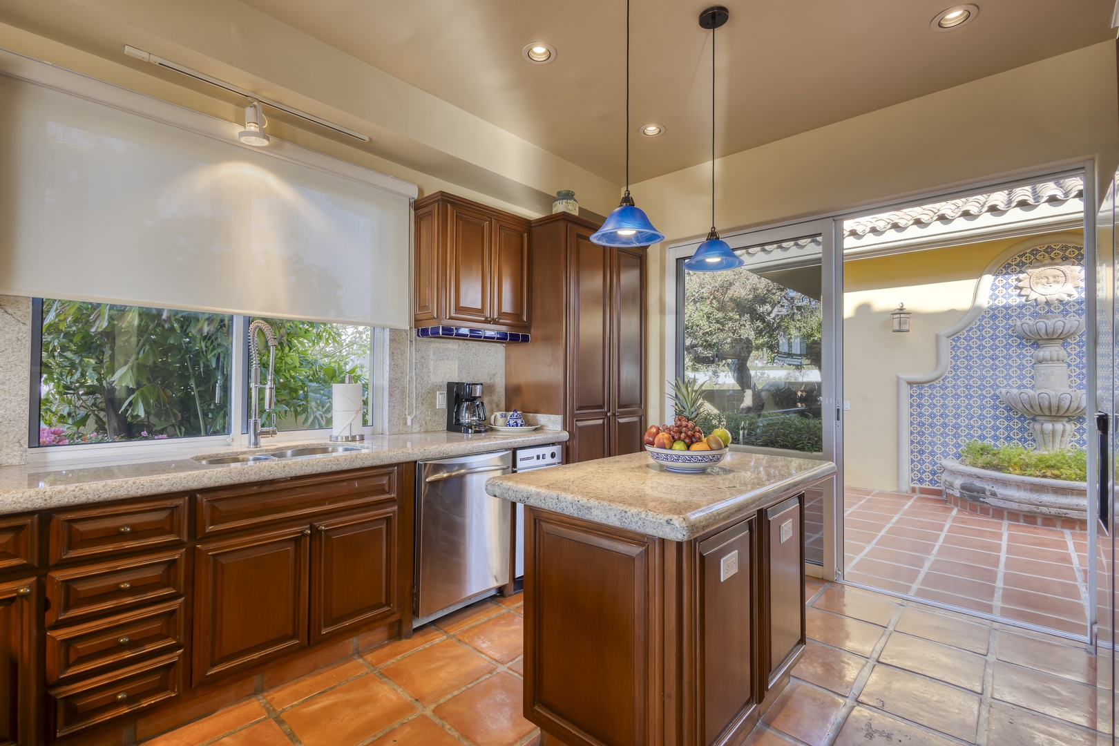 Your gourmet kitchen awaits with rich wood cabinetry, granite countertops, and garden views through every window.