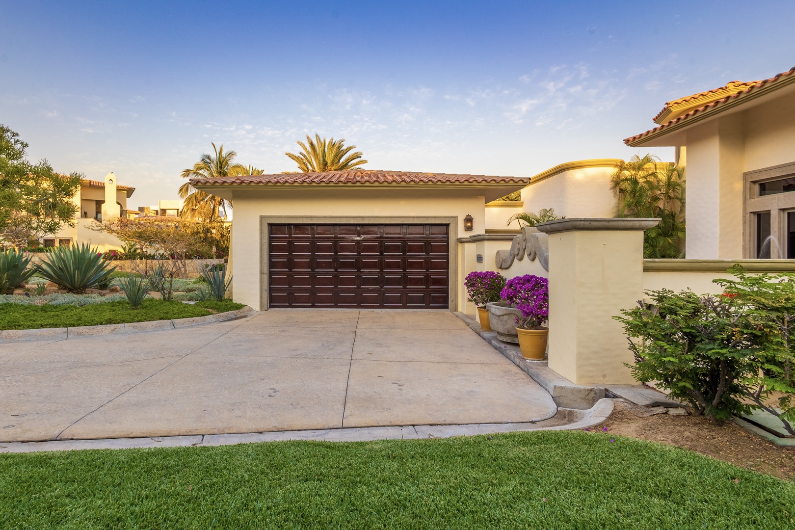 Mediterranean-style villa nestled in a lush desert setting with manicured lawns, vibrant landscaping, and welcoming Spanish-tile architecture that creates the perfect vacation retreat.