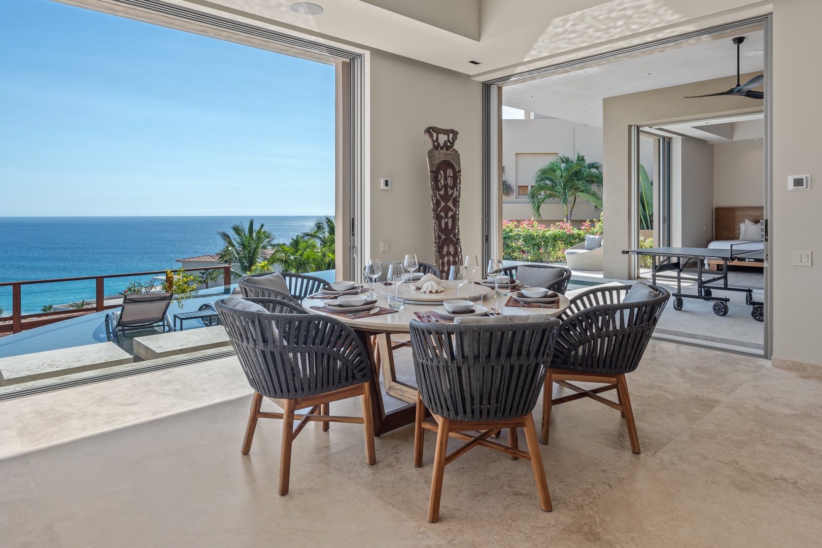 Picture yourself enjoying meals at this elegant dining table with sweeping ocean views framing every moment. The open layout and floor-to-ceiling windows invite refreshing sea breezes right to your table.