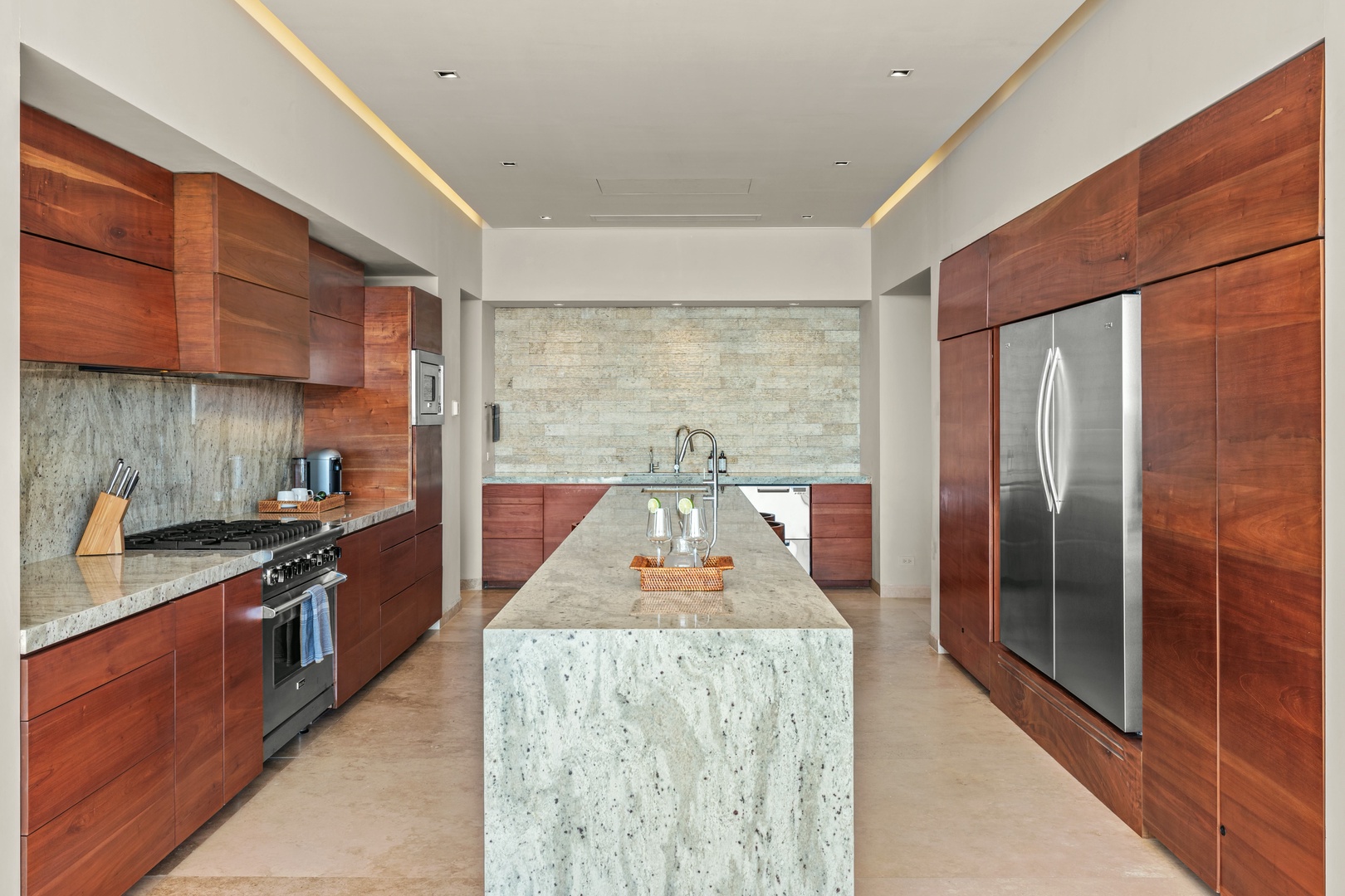 Your chef-ready kitchen features rich wood cabinetry, granite countertops, stainless steel appliances, and a stunning waterfall island—perfect for preparing meals or gathering with loved ones.