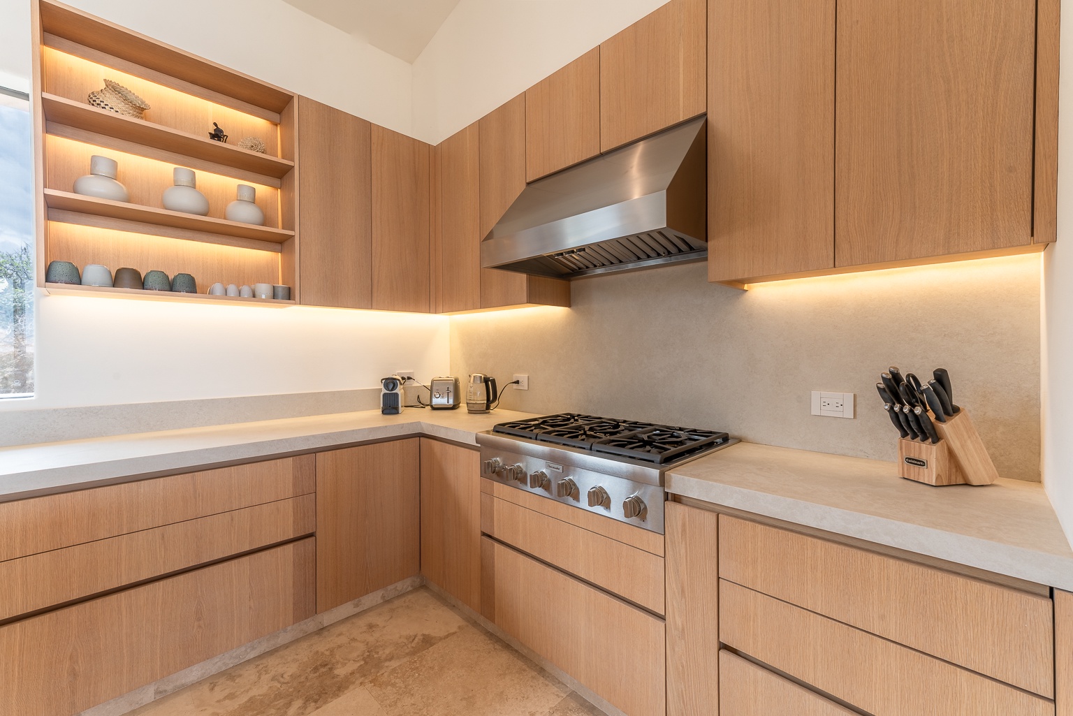Discover your culinary haven: warm wood cabinetry, professional-grade appliances, and ambient lighting create the perfect space for memorable meals and late-night snacks during your stay.