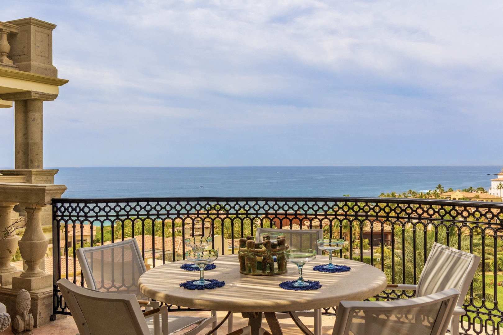 Your private balcony offers stunning sea views while you dine alfresco, with elegant table settings awaiting your arrival.