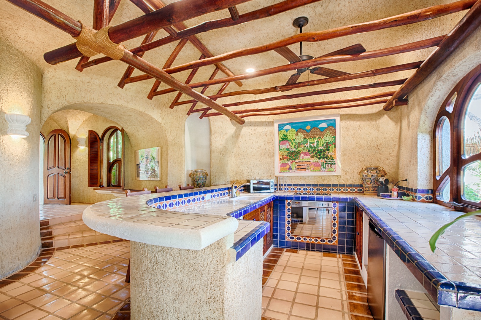 Your hacienda-style kitchen awaits with handcrafted tile work, warm terracotta floors, and rustic beamed ceilings that frame your culinary adventures.
