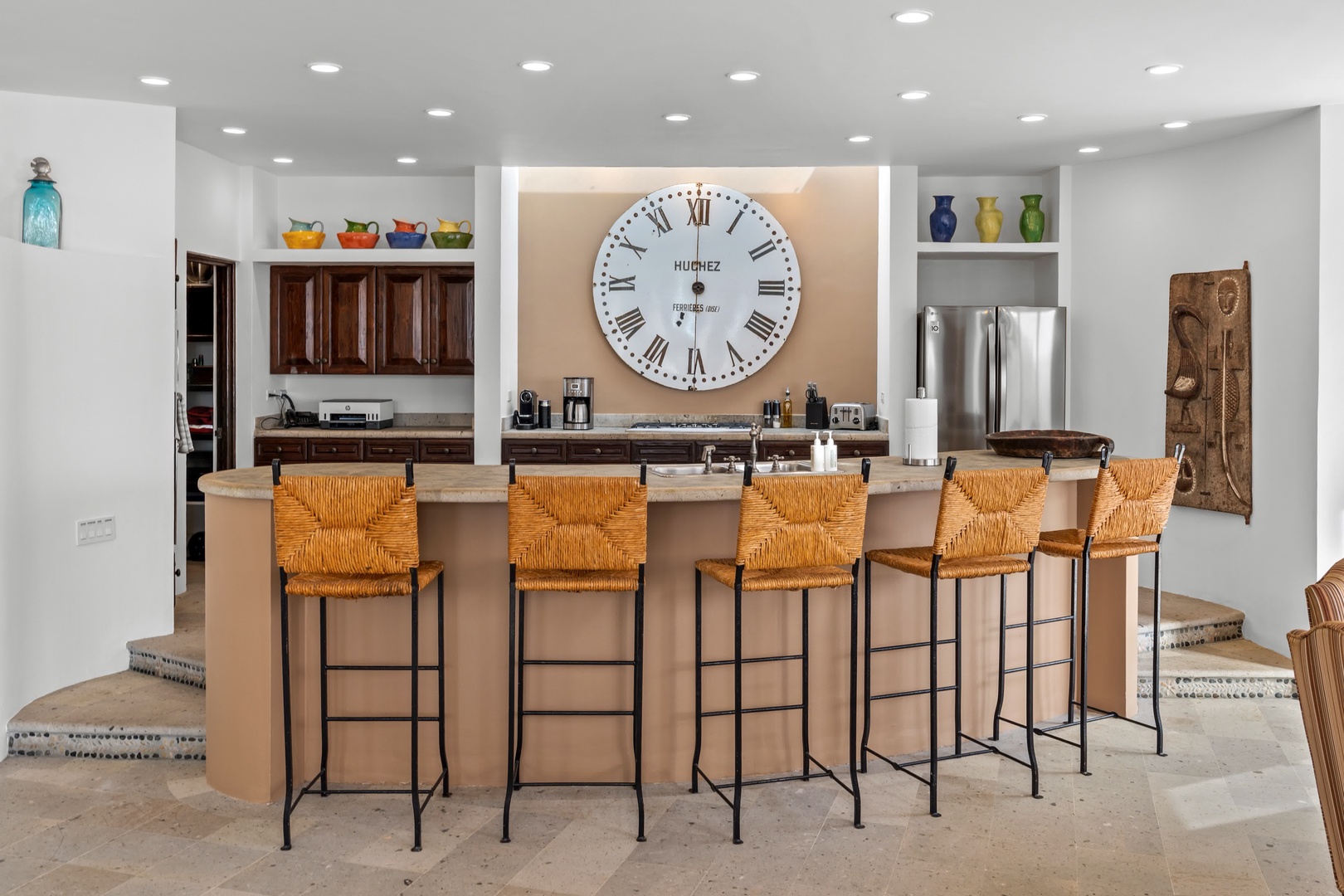 Gather around this stunning kitchen island where morning coffee and evening conversations flow effortlessly under warm lighting.