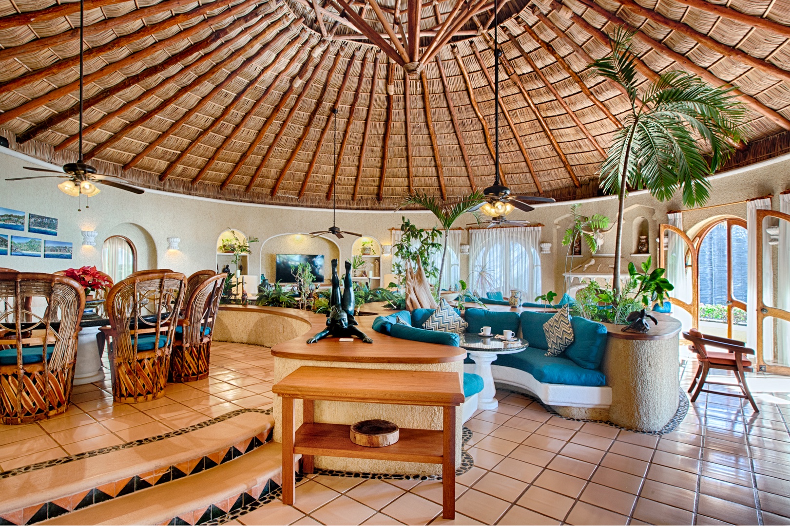 Relax in your stunning palapa-style living space with soaring thatched ceilings, tropical decor, and vibrant turquoise seating perfect for unwinding.