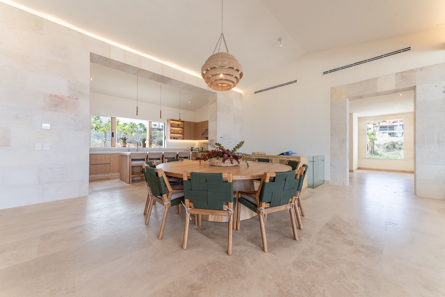 Gather around the elegant round dining table for memorable meals in this bright, modern space with sleek design touches and a stunning pendant light overhead.