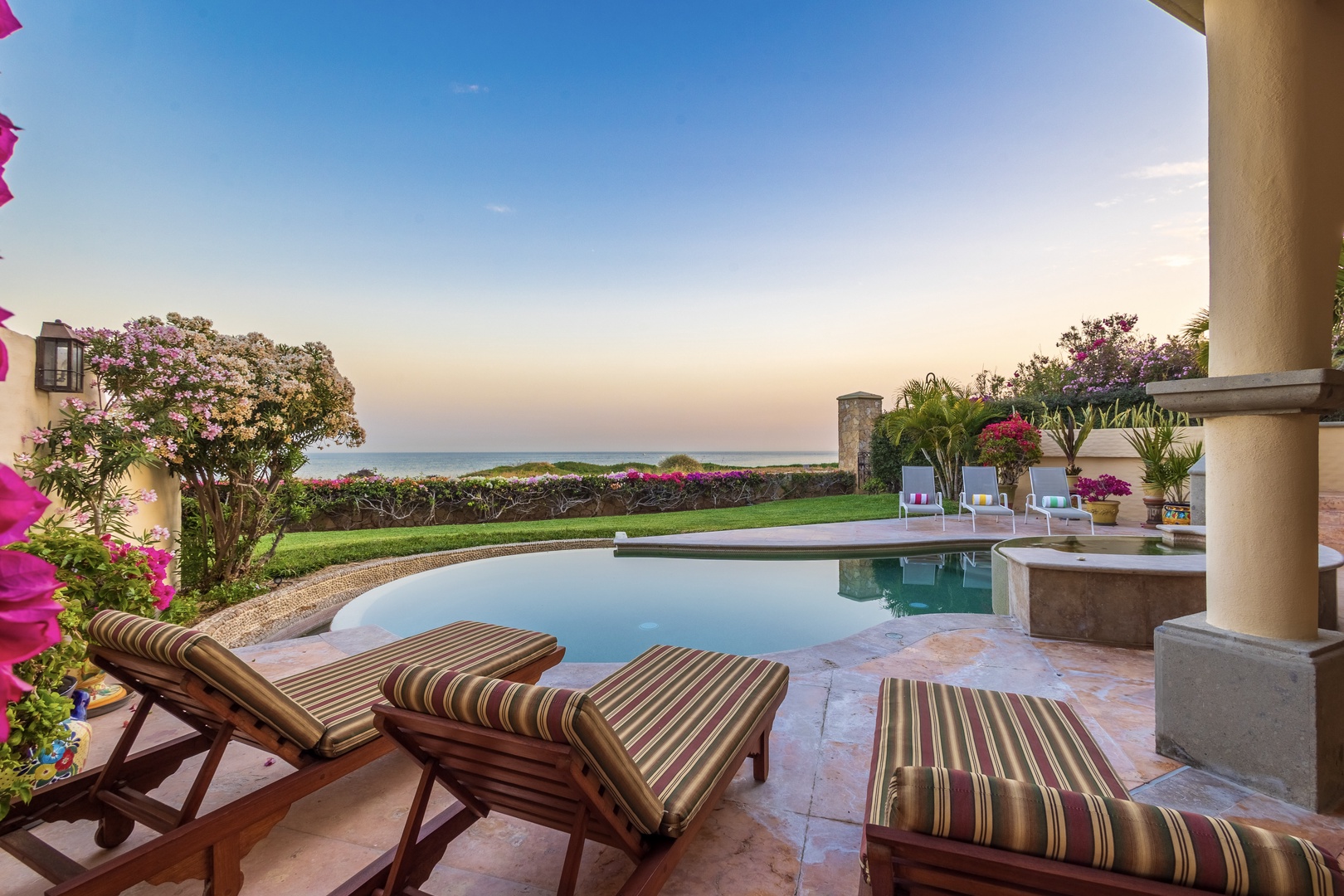 Unwind on your private terrace with stunning sea views, where the infinity pool meets lush gardens and vibrant bougainvillea frames endless blue horizons—your peaceful coastal escape awaits.