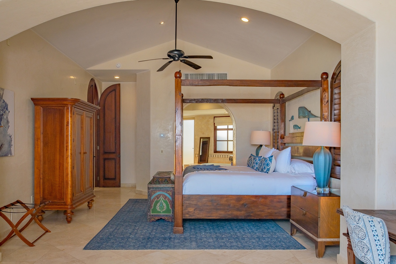 Unwind in your elegant four-poster bedroom featuring handcrafted furniture, soaring vaulted ceilings, and tropical touches that create the perfect peaceful retreat.
