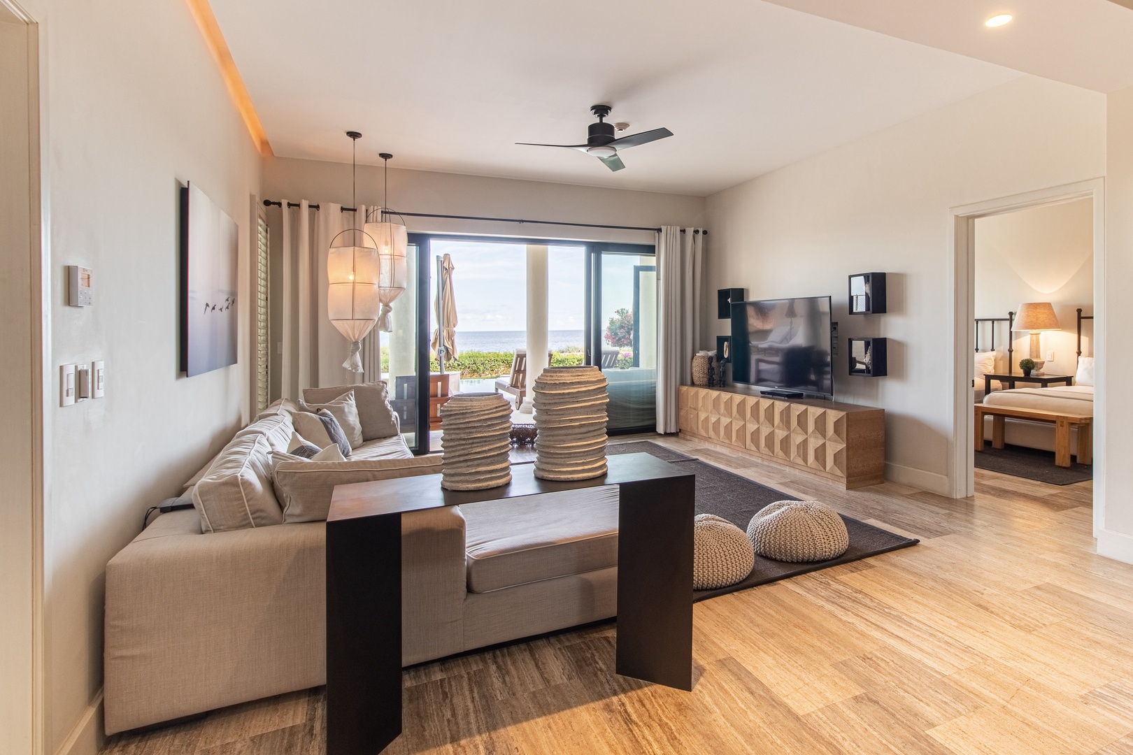 Your bright, open living area beckons with coastal views beyond—relax on the plush seating and feel the sea breeze as natural light fills this modern sanctuary.