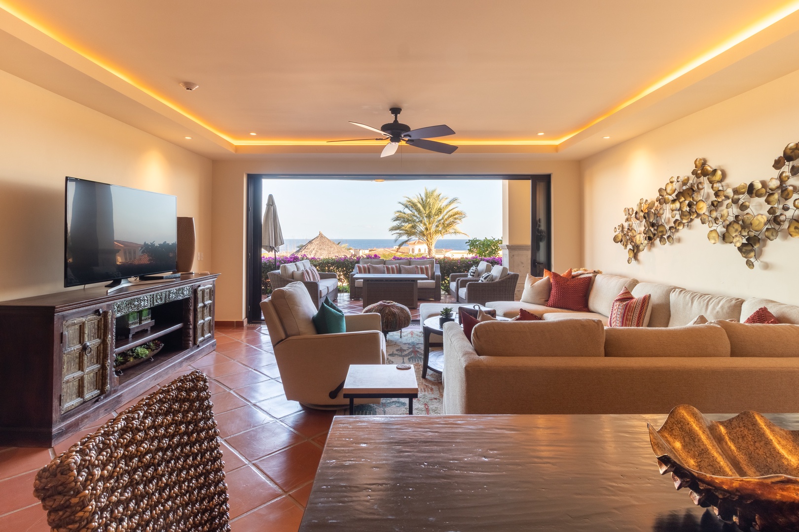 Sink into plush seating and enjoy sunset views of the ocean. This open-plan living area flows seamlessly to your private terrace, where beach lounging awaits.