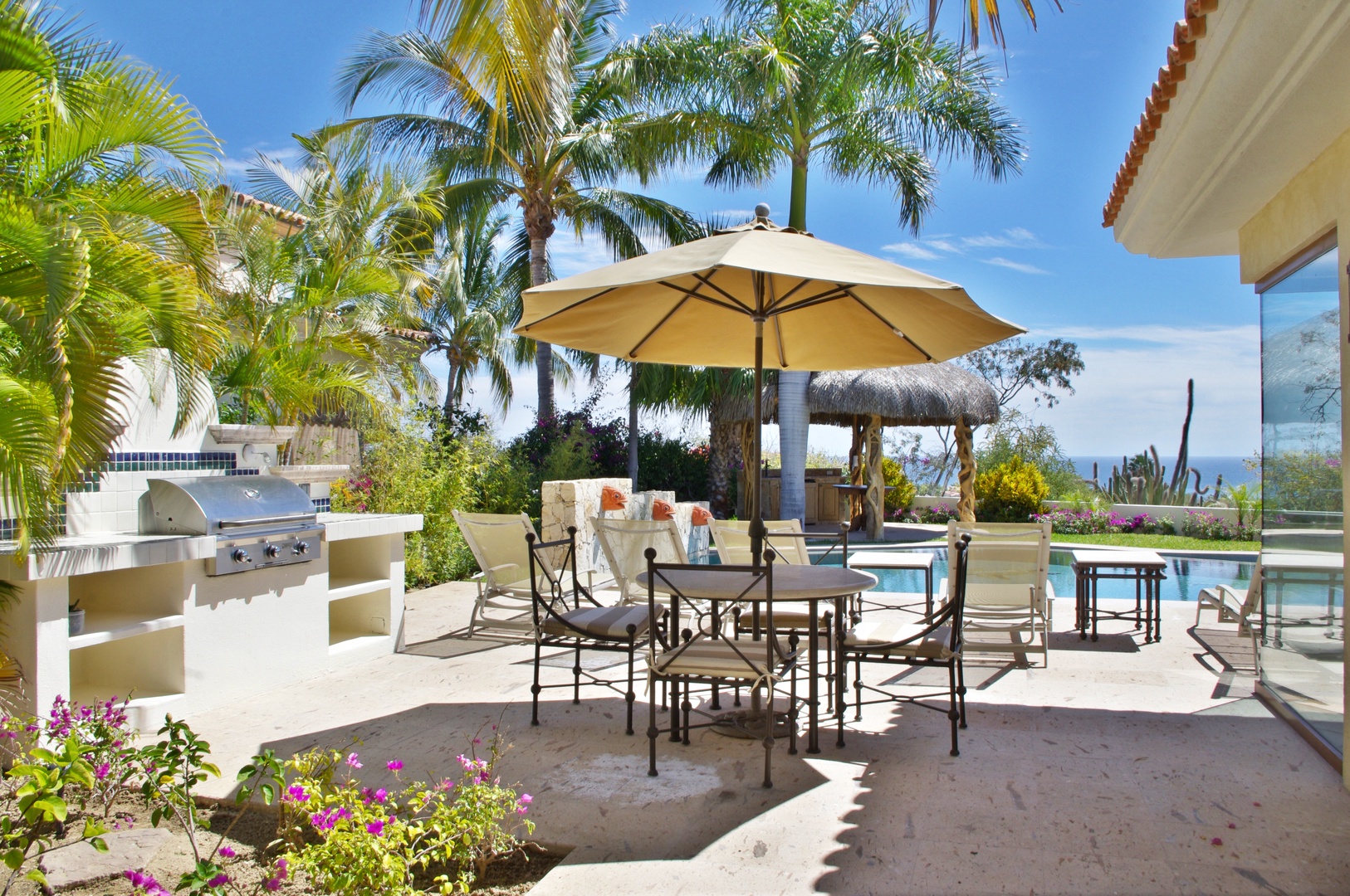 Your private outdoor haven awaits: dine under the sun at your patio table, grill fresh catches on the built-in BBQ, then lounge poolside surrounded by swaying palms and vibrant blooms.