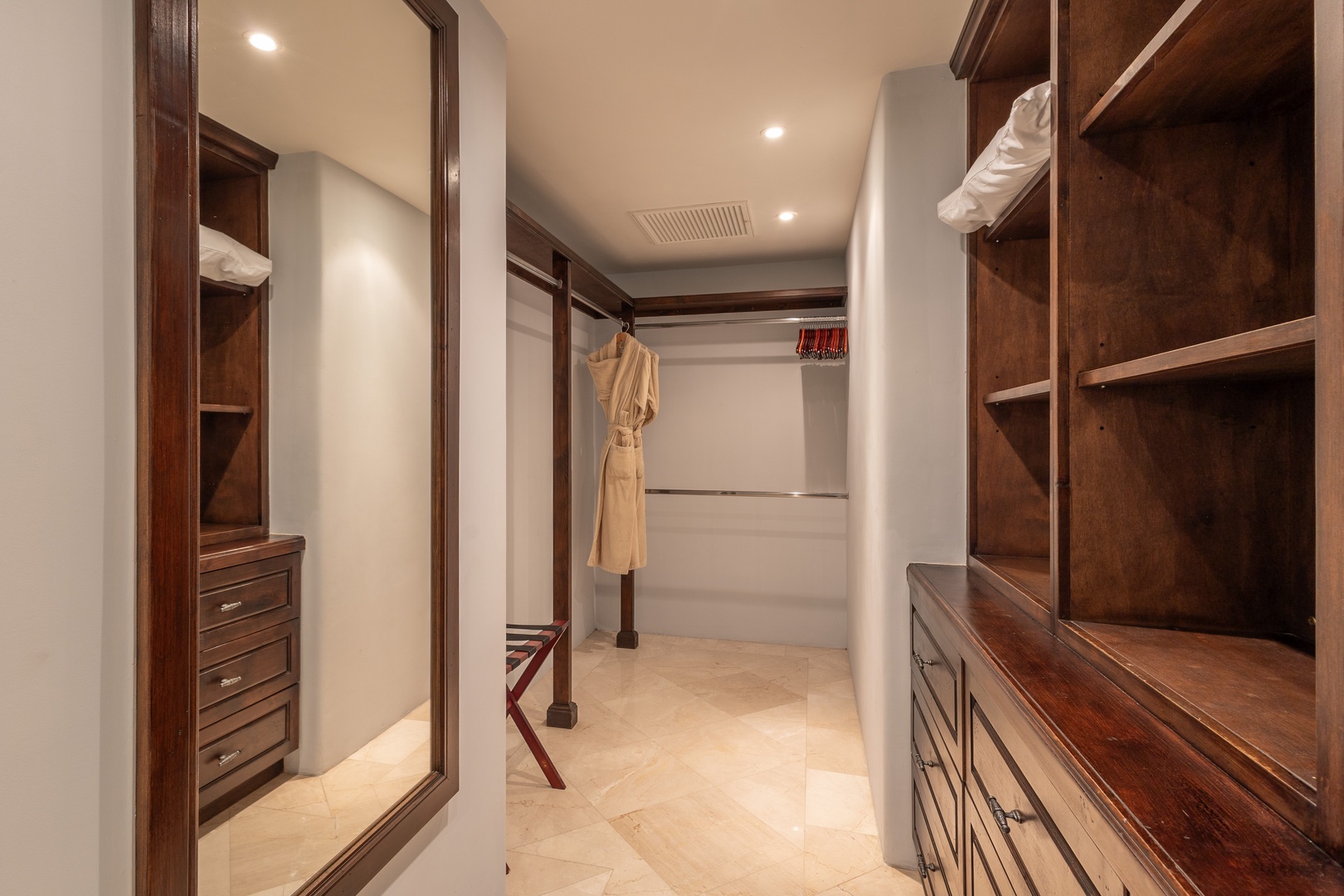 Step into your private walk-in closet with custom wood shelving and ample hanging space to organize everything you brought for your stay.