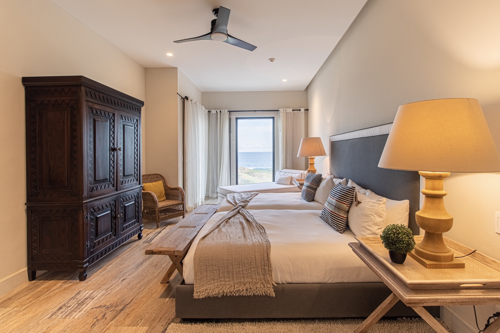 Wake up to stunning ocean views in your serene bedroom. Enjoy plush bedding, coastal decor, and gentle sea breezes through your window. Relax and recharge in this peaceful retreat.