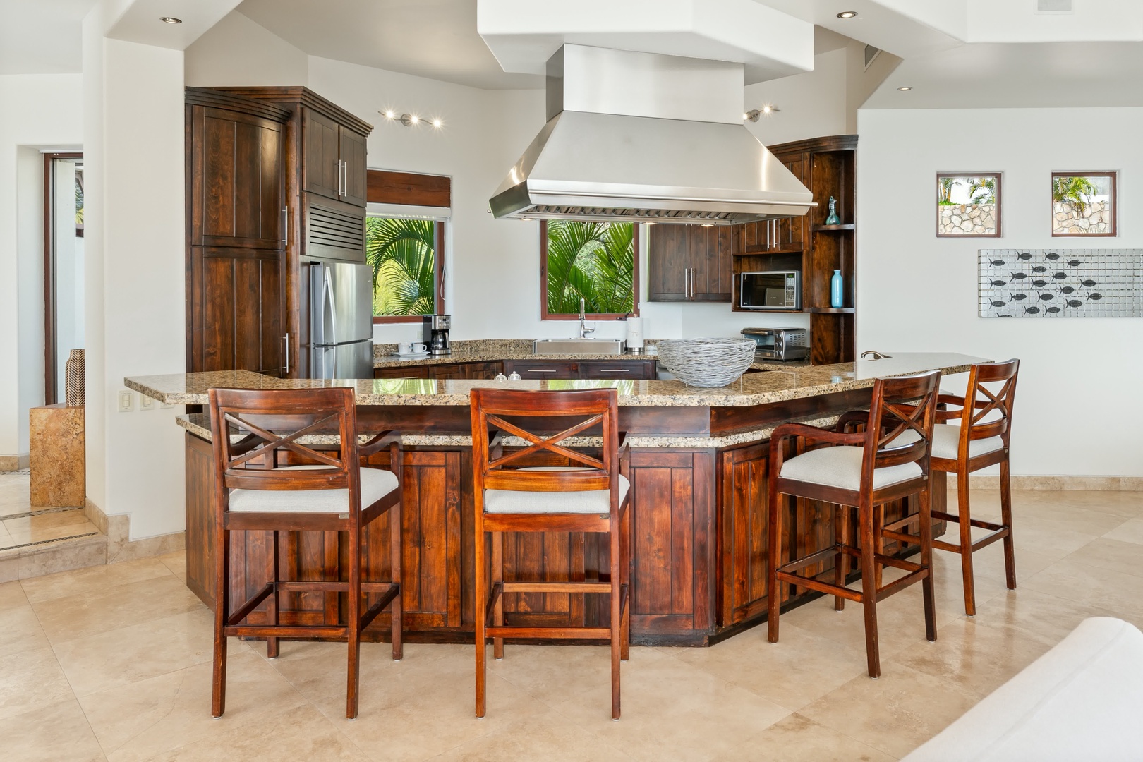 Your gourmet kitchen features granite countertops, rich wood cabinetry, and bar seating perfect for morning coffee or evening gatherings.