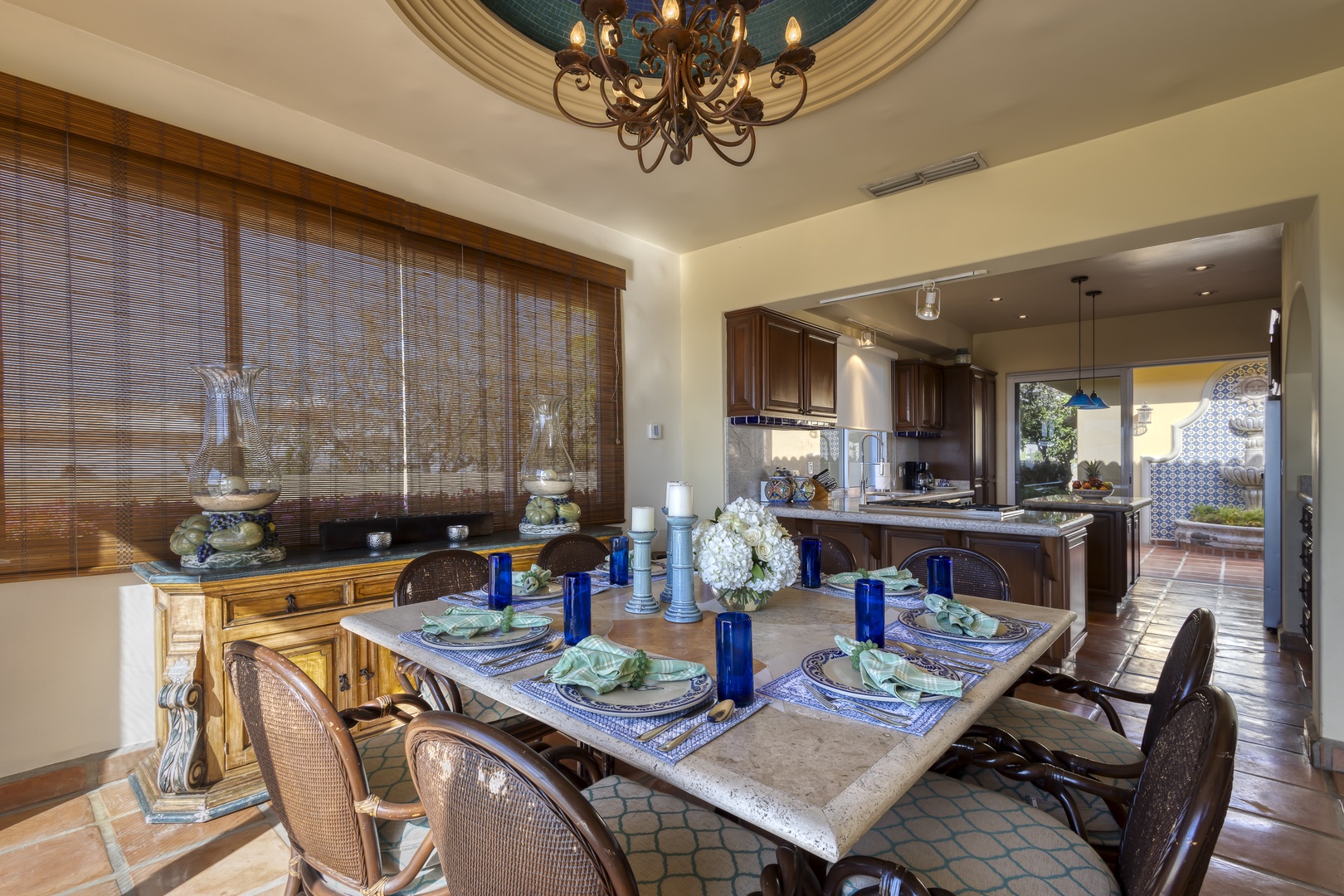 Gather around this elegant dining table where memorable meals unfold beneath a stunning chandelier, perfectly positioned between your gourmet kitchen and serene outdoor spaces.
