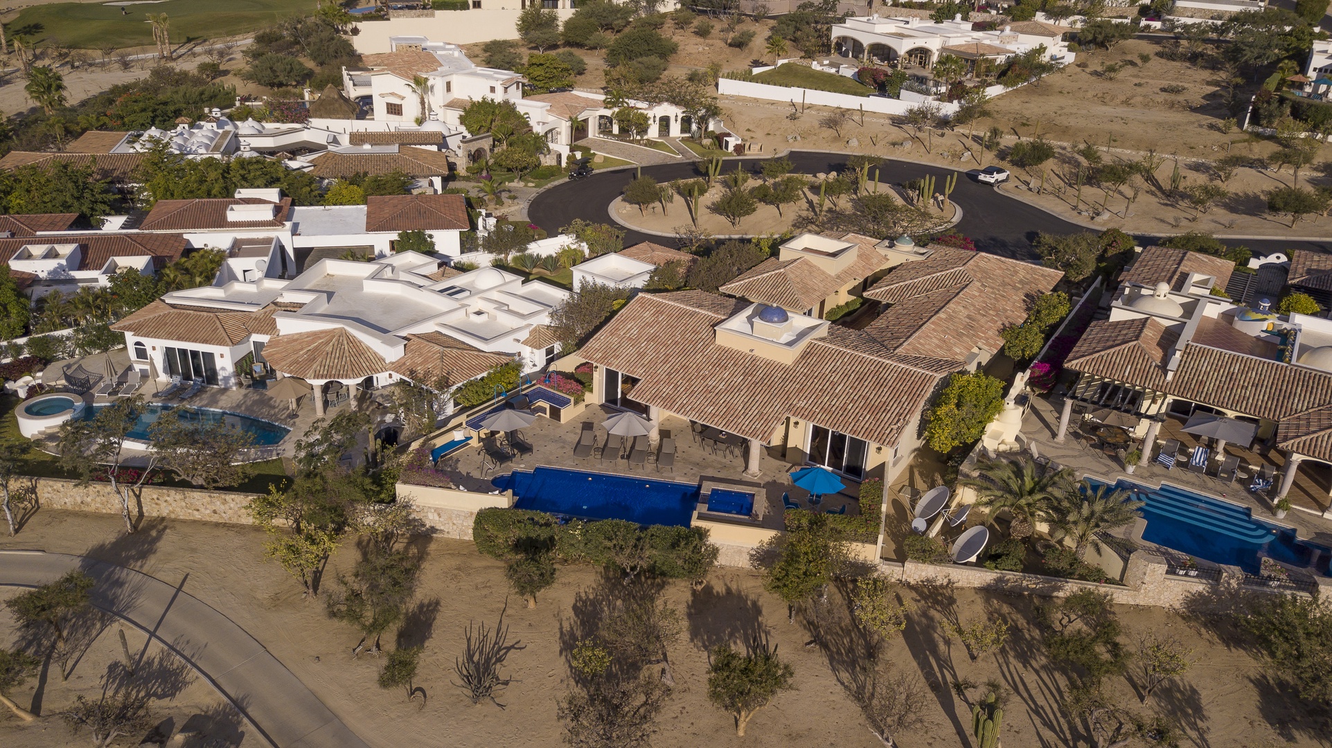 Aerial view showcasing the property's spacious layout with private pools and lush landscaping in a serene residential neighborhood.
