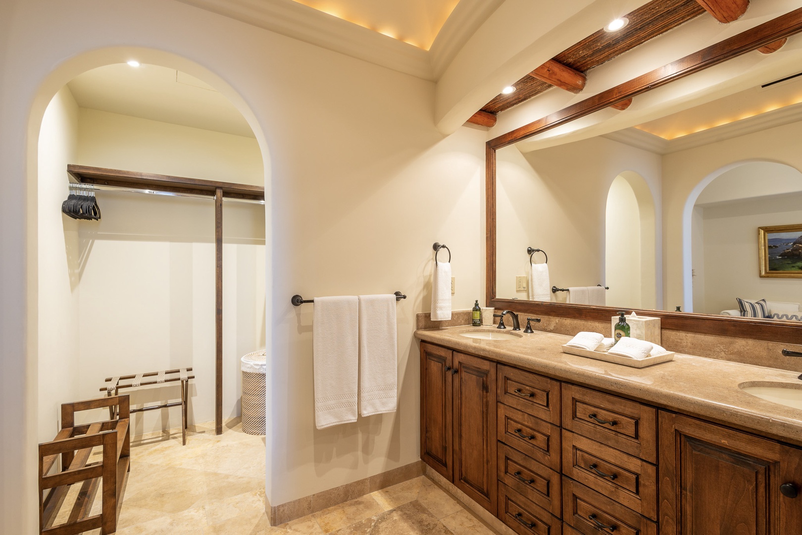 Step into your serene retreat with dual vanities, natural stone, and rustic wood beams creating a warm, spa-like atmosphere. Fresh towels await your arrival after a day of exploring.