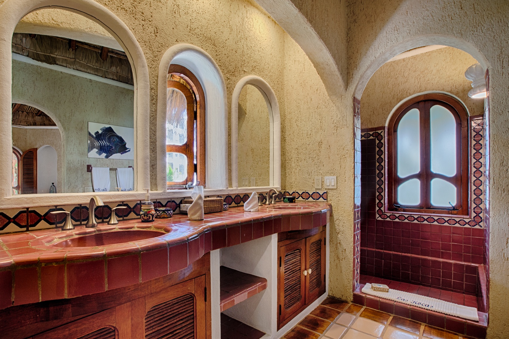 Step into your beautifully tiled bathroom featuring arched windows, rich terracotta details, and authentic Mexican craftsmanship throughout.