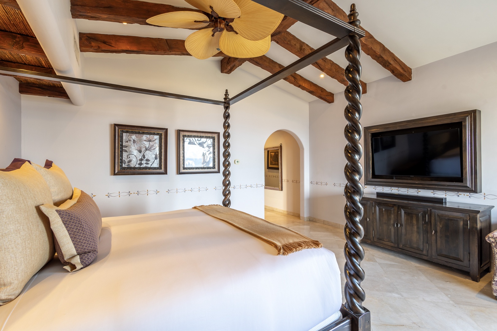 Step into your serene retreat with vaulted wood-beam ceilings and a striking canopy bed that invites restful nights. Relax in tropical-inspired elegance with modern comforts at your fingertips.