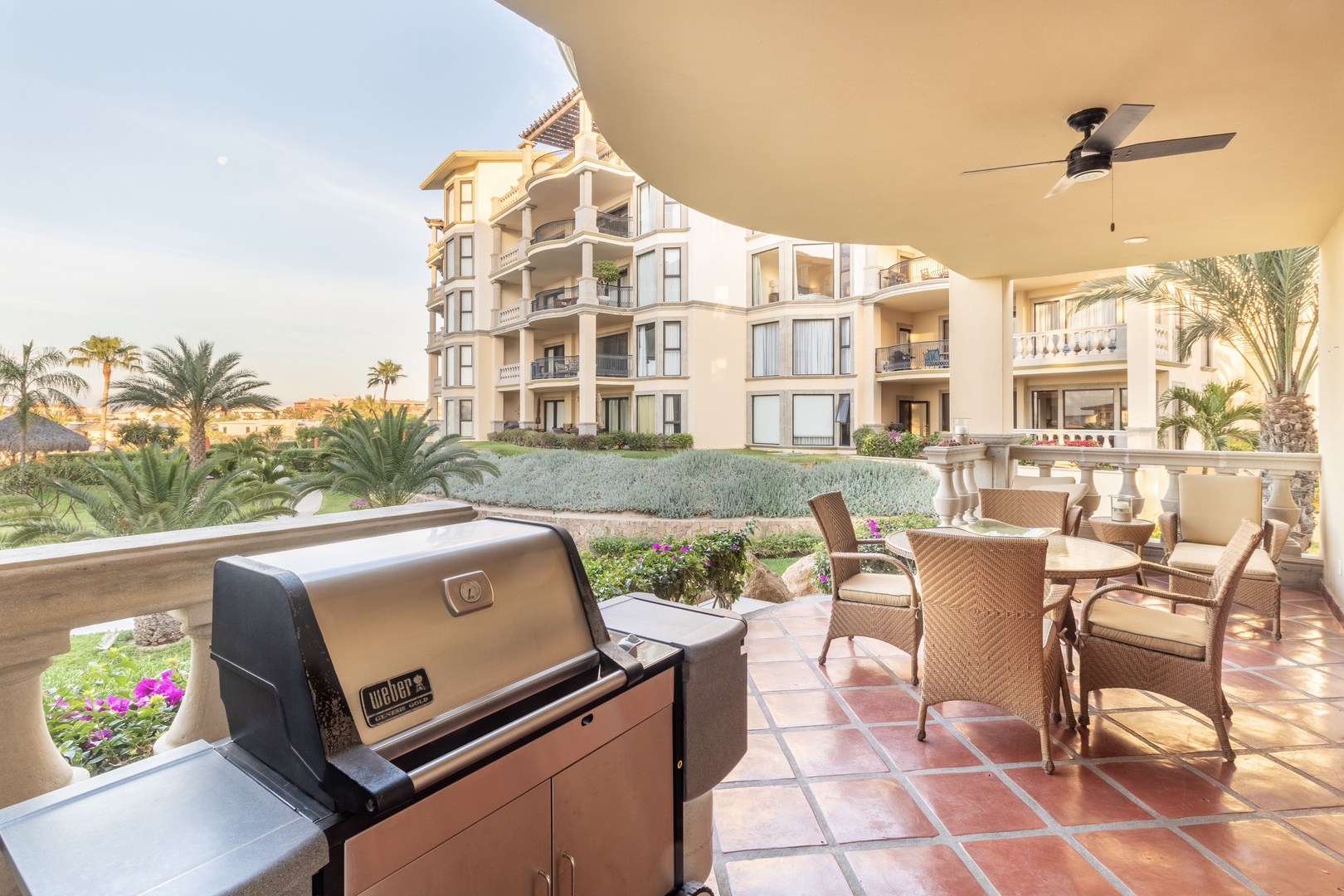 Your private balcony features a built-in gas grill and comfortable seating, perfect for grilling while enjoying tropical landscaping and resort views during warm evenings.