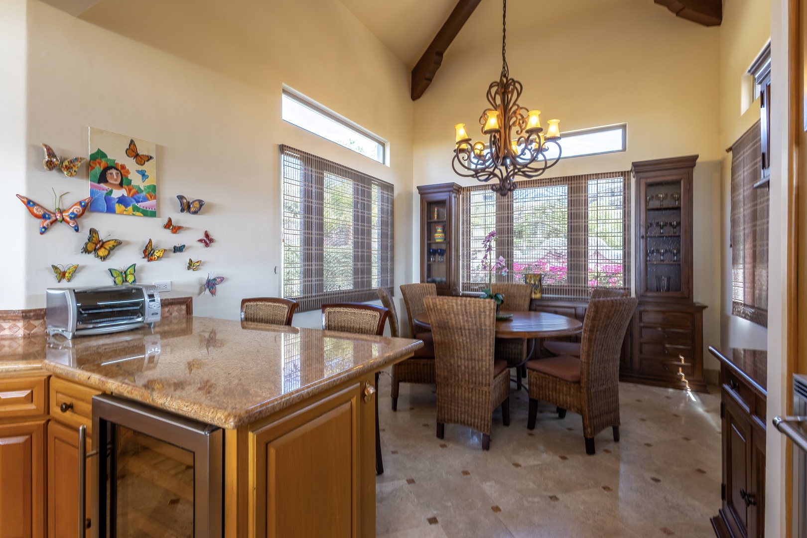 Step into a bright, open dining space where vaulted ceilings and charming chandelier light create an inviting atmosphere for your meals. The full kitchen and elegant dining table make this your perfect home base for gathering and relaxing together.