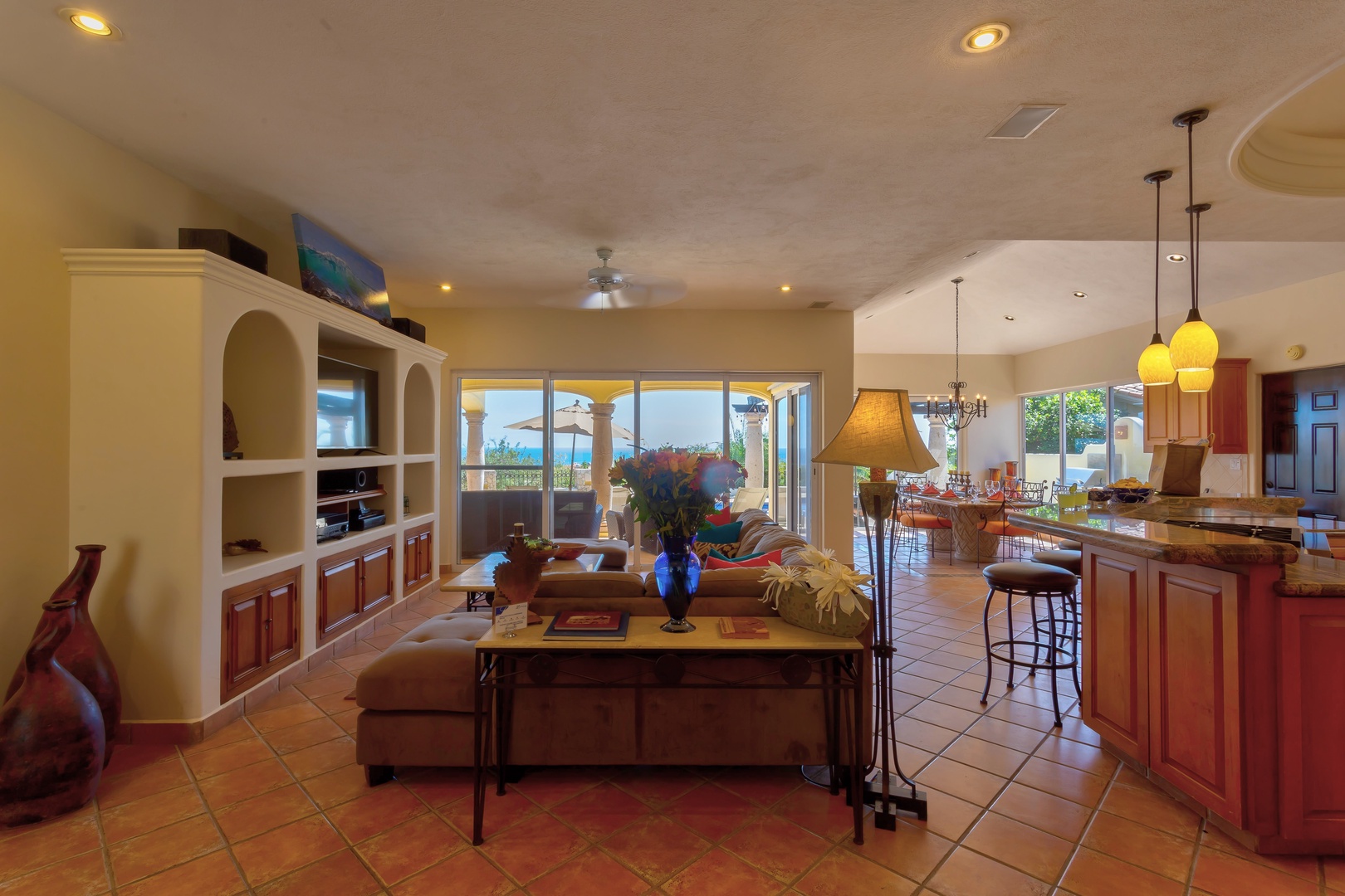 Unwind in this open-concept living space where warm tile floors and rich wood cabinetry create your perfect home base for relaxation.
