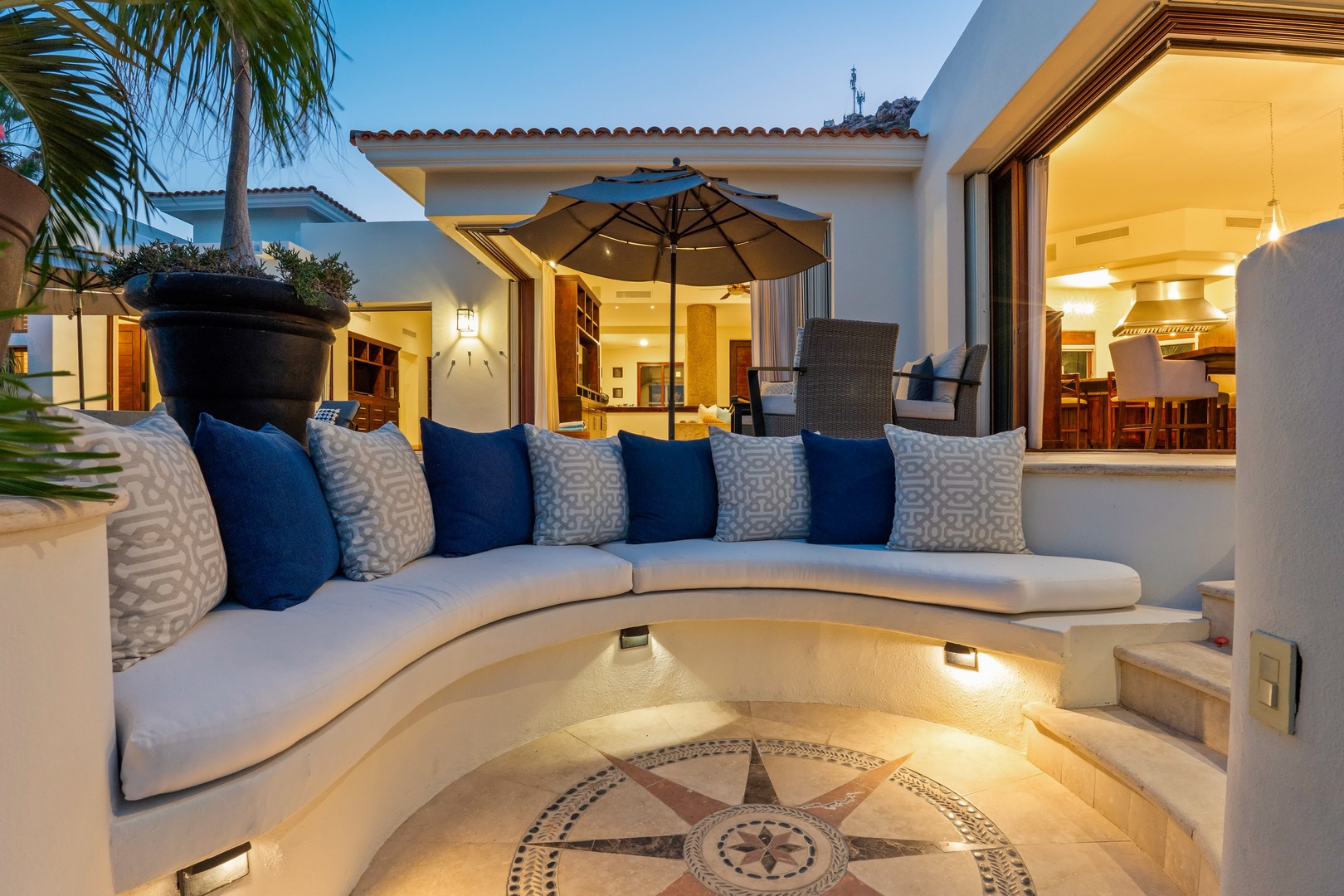 Sink into this curved outdoor sofa and unwind as warm evening light creates the perfect ambiance for relaxation.