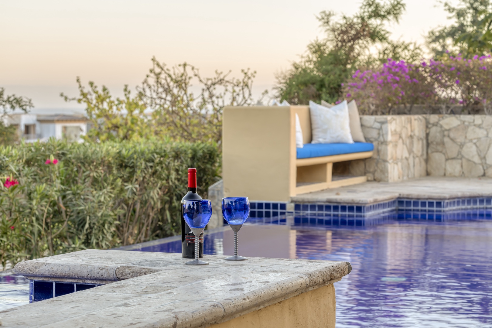 Unwind poolside with evening wine, cushioned seating, and lush gardens creating your perfect retreat sanctuary.